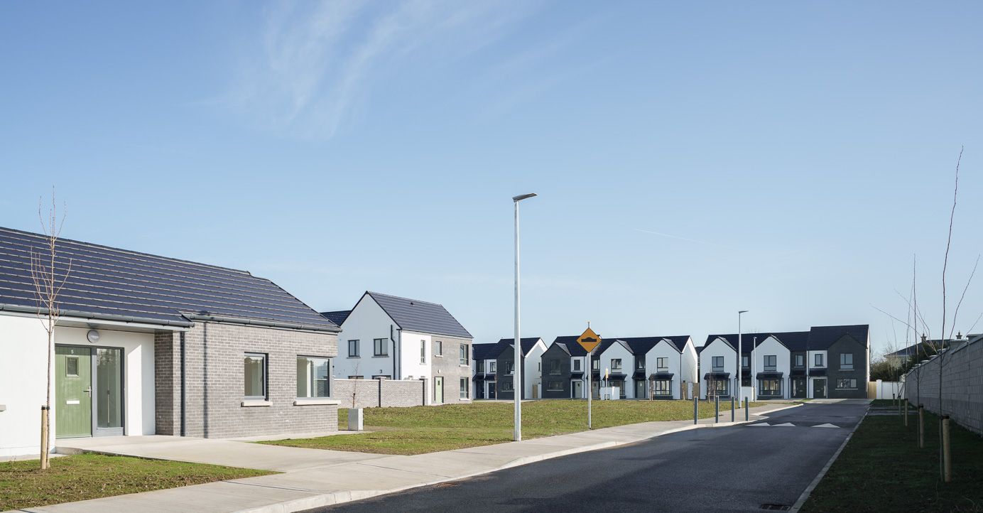A row of houses with solar panels on the roofs in a residential area.