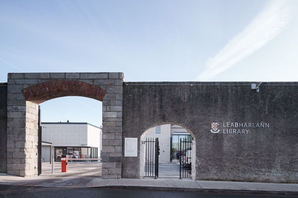 The entrance to a building with a stone archway and a gate.