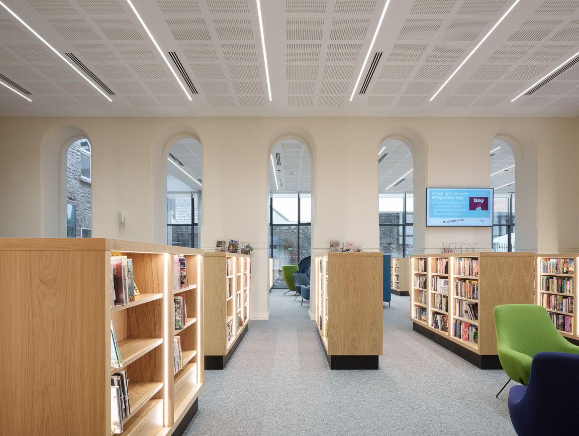 A library with wooden shelves and a green chair