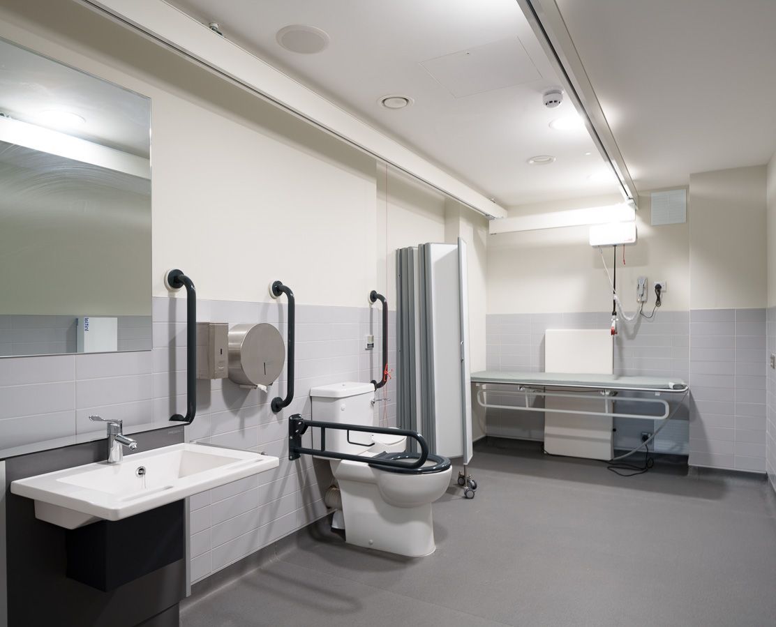 A bathroom with a toilet , sink and mirror