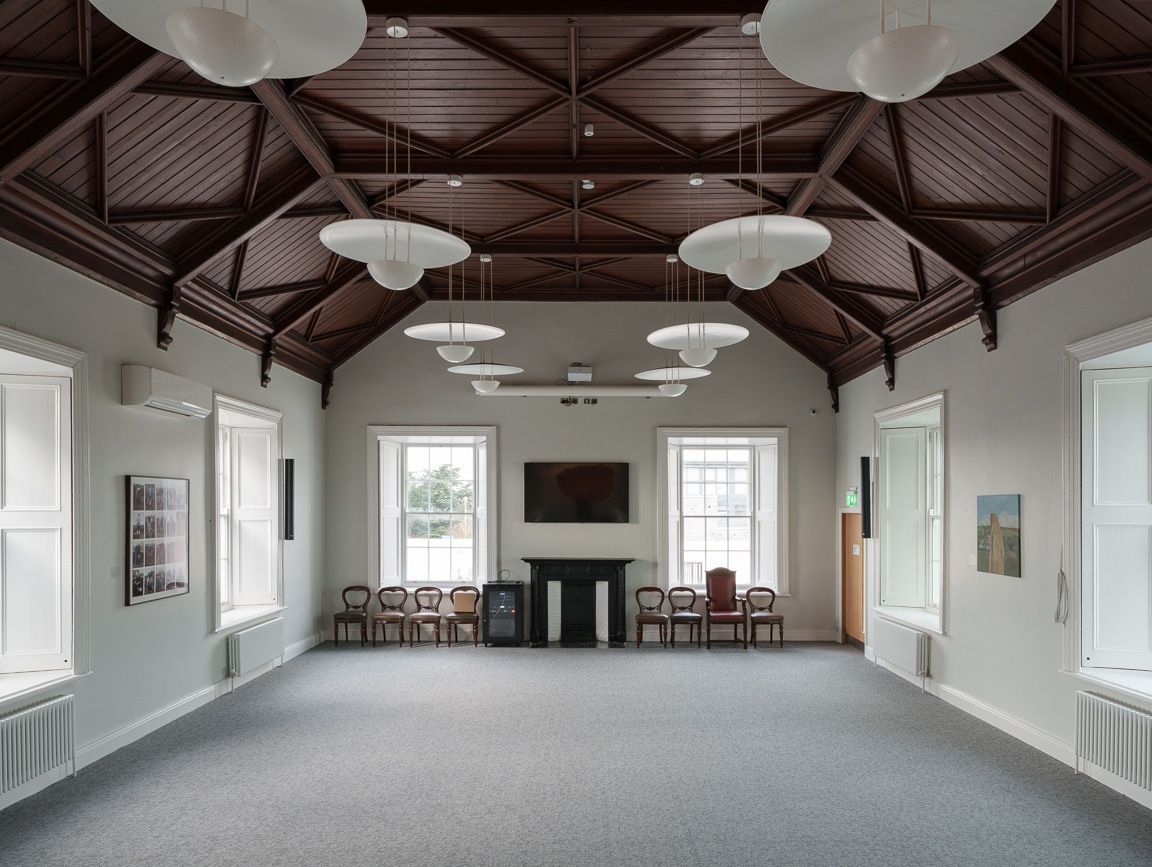 A large room with a fireplace and lots of windows