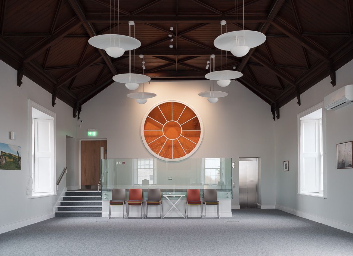A large empty room with a circular painting on the wall