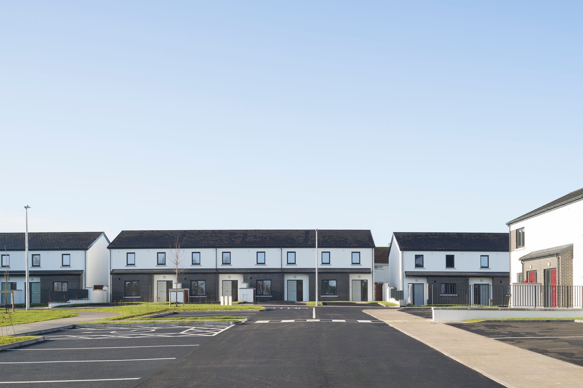 A row of houses with a parking lot in front of them