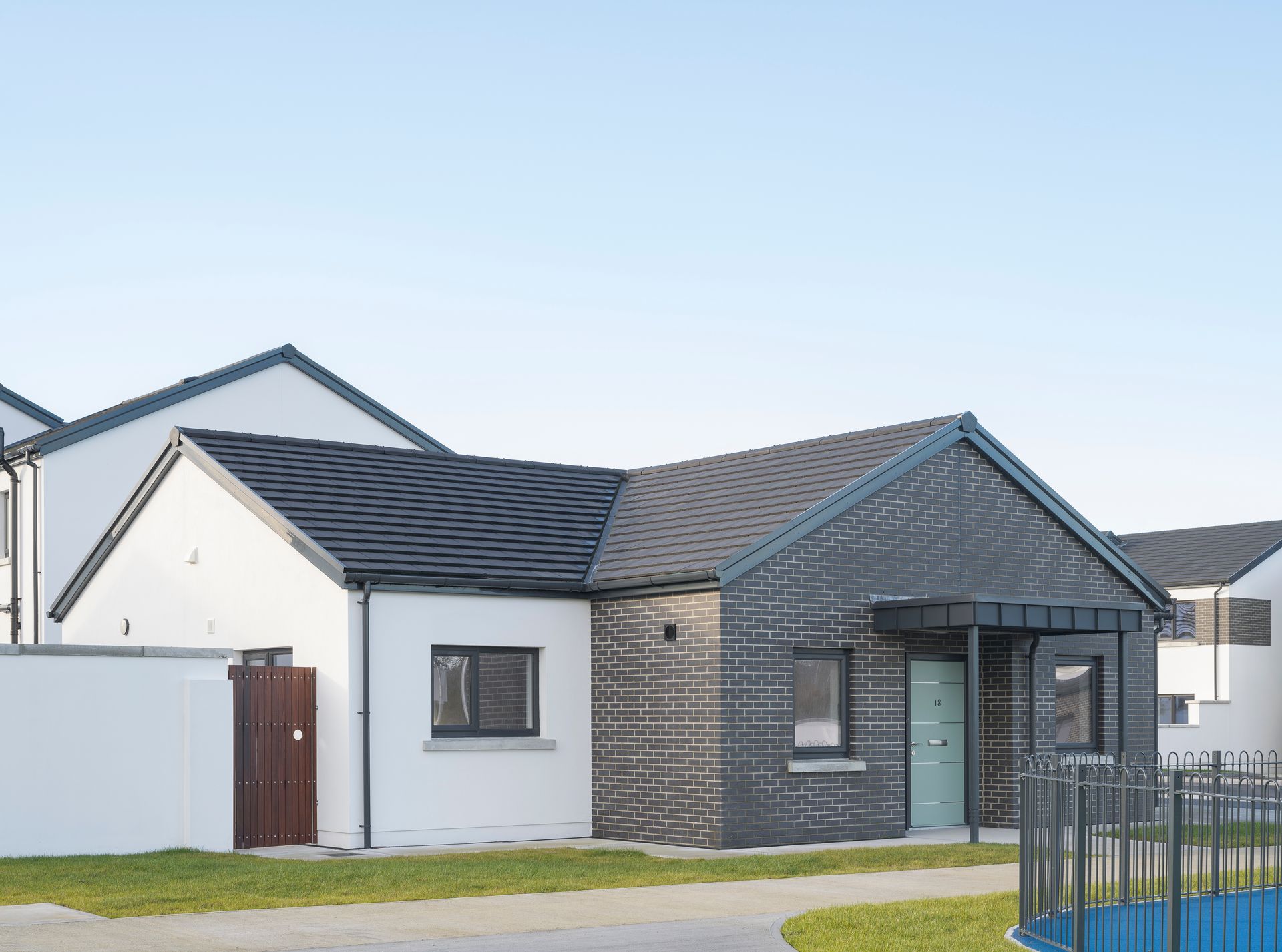 A white house with a black roof and a blue door