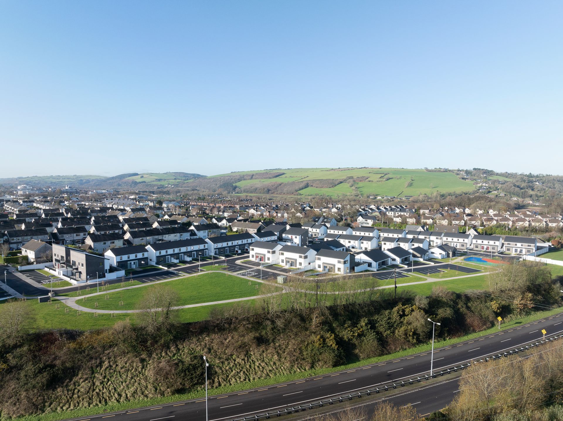 An aerial view of a residential area with a road going through it.