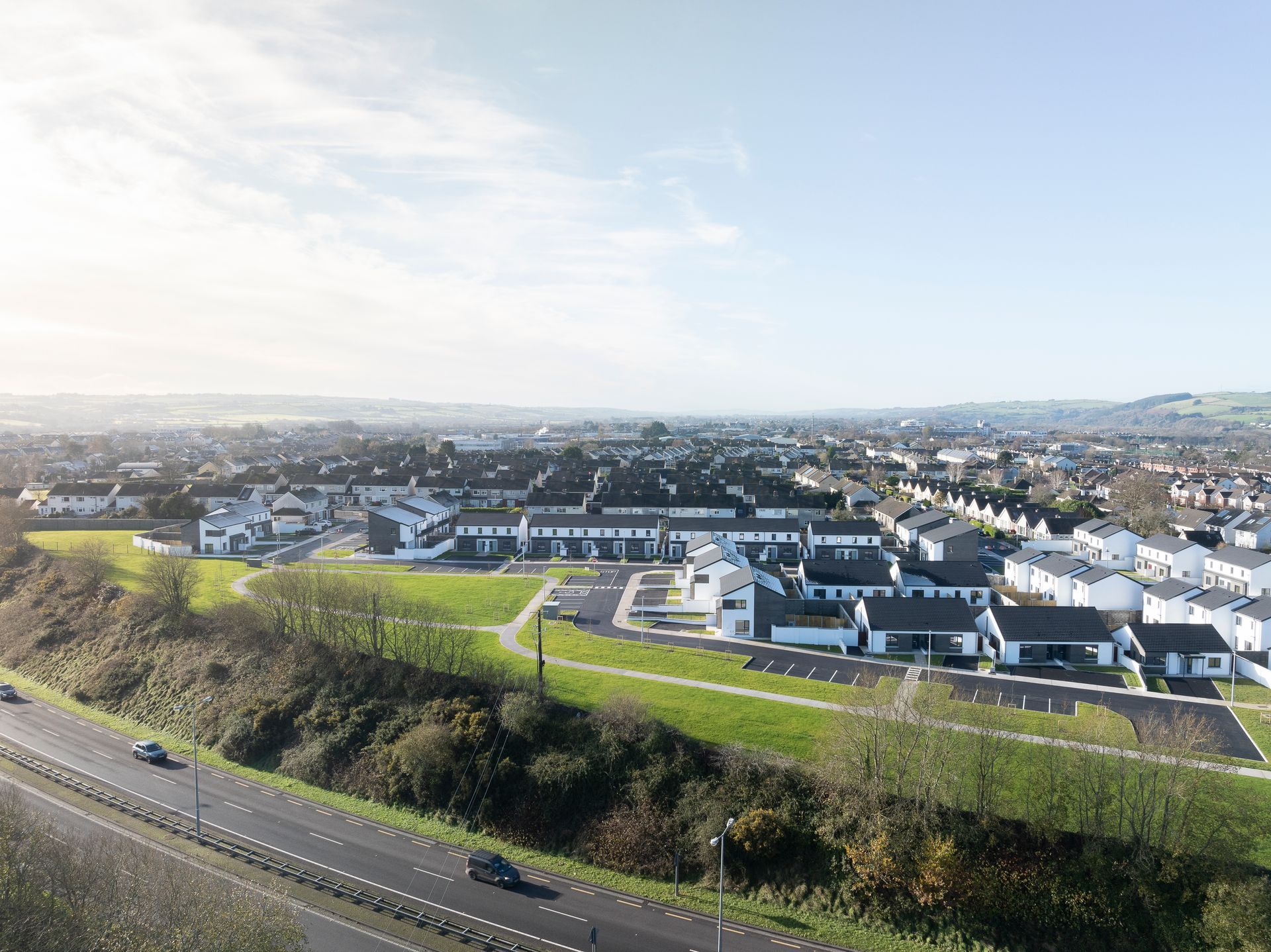 An aerial view of a residential area next to a highway.