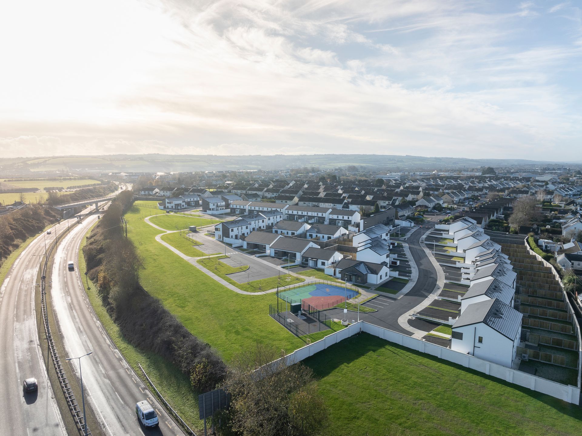 An aerial view of a residential area next to a highway.