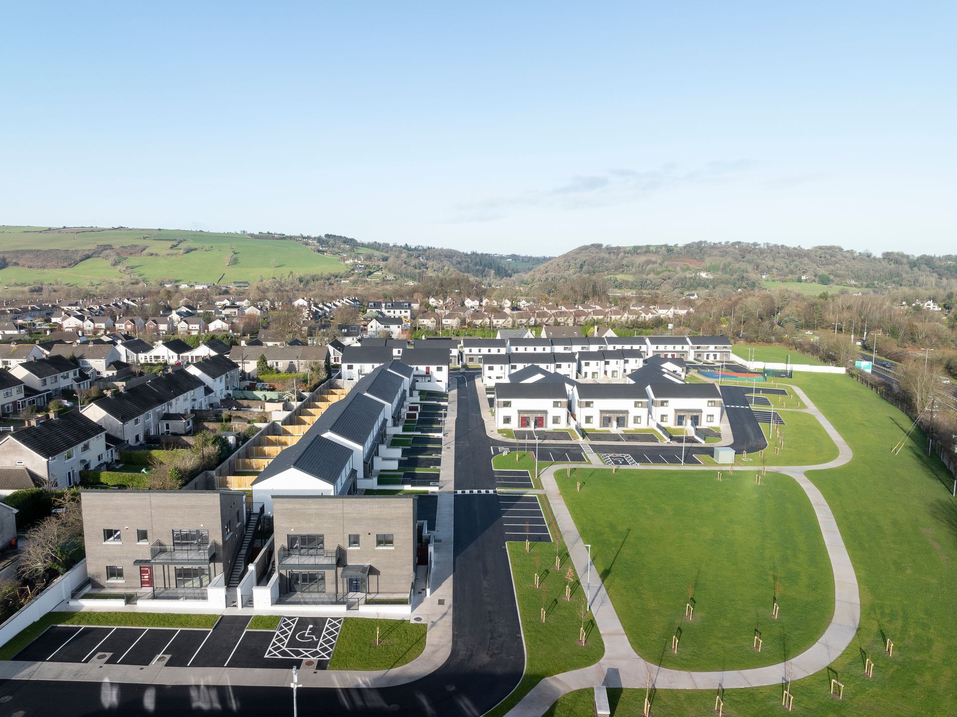 An aerial view of a residential area with houses and a park
