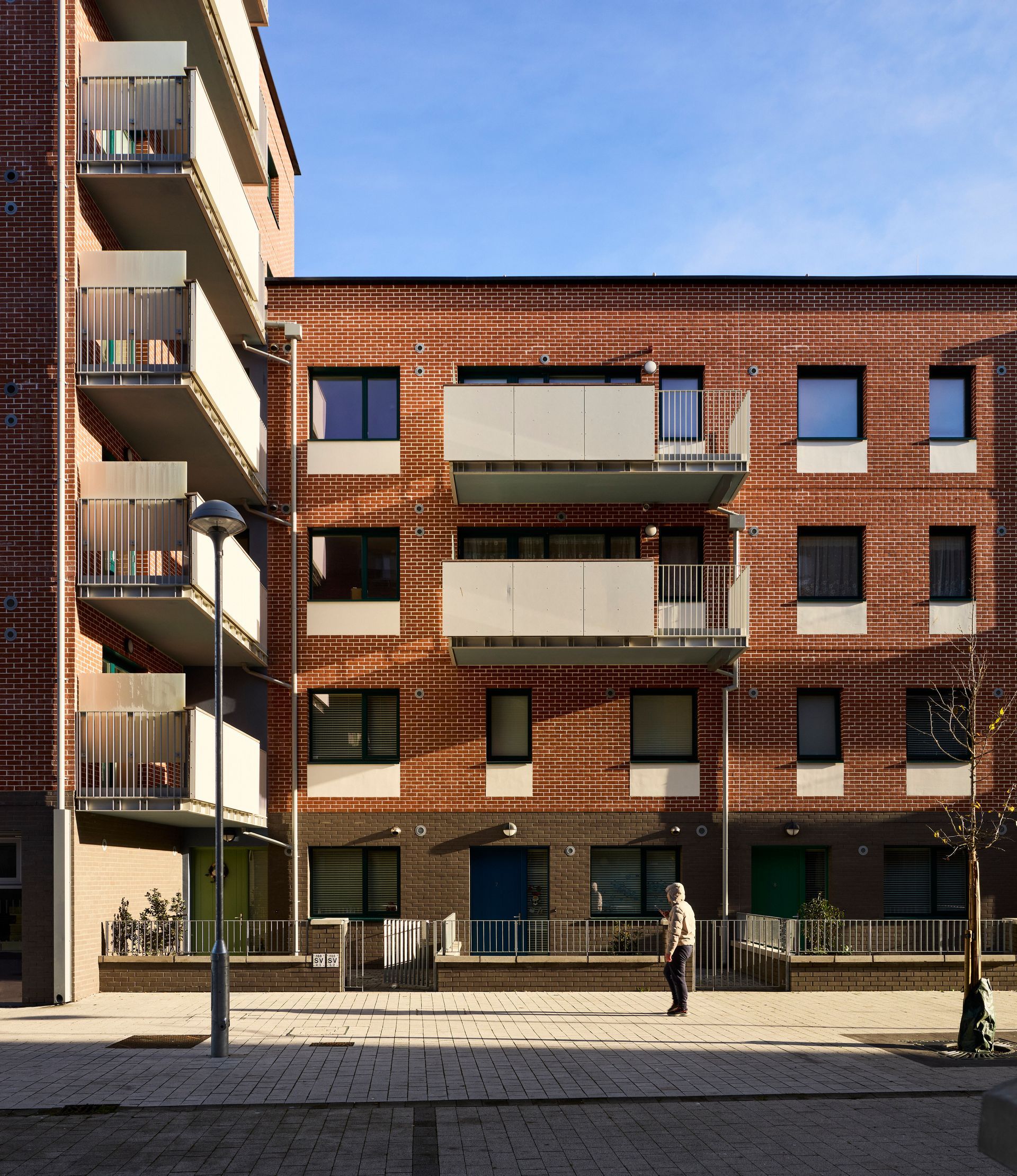 A brick building with balconies and a blue door