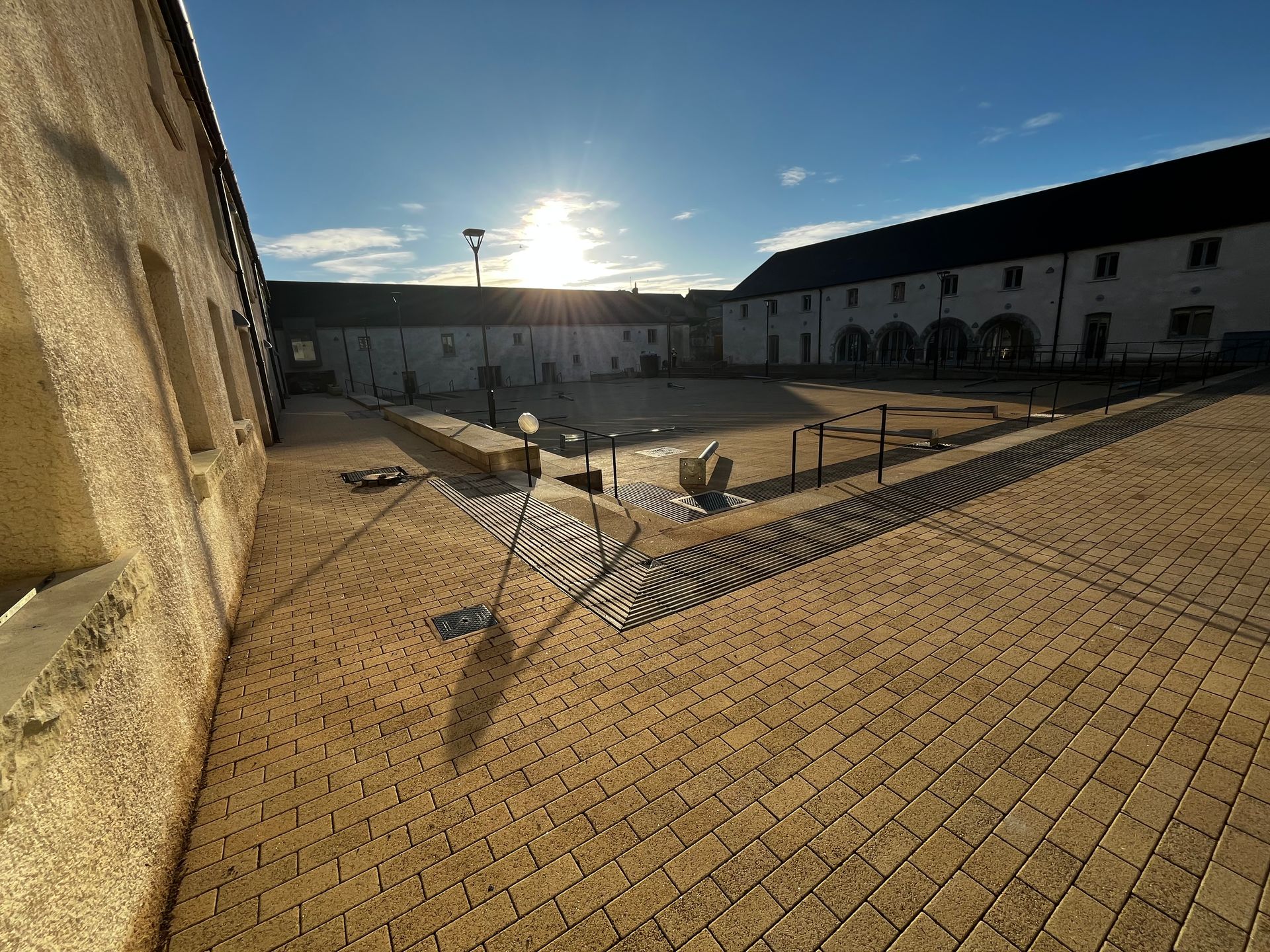 The sun is shining through the windows of a building in a courtyard.