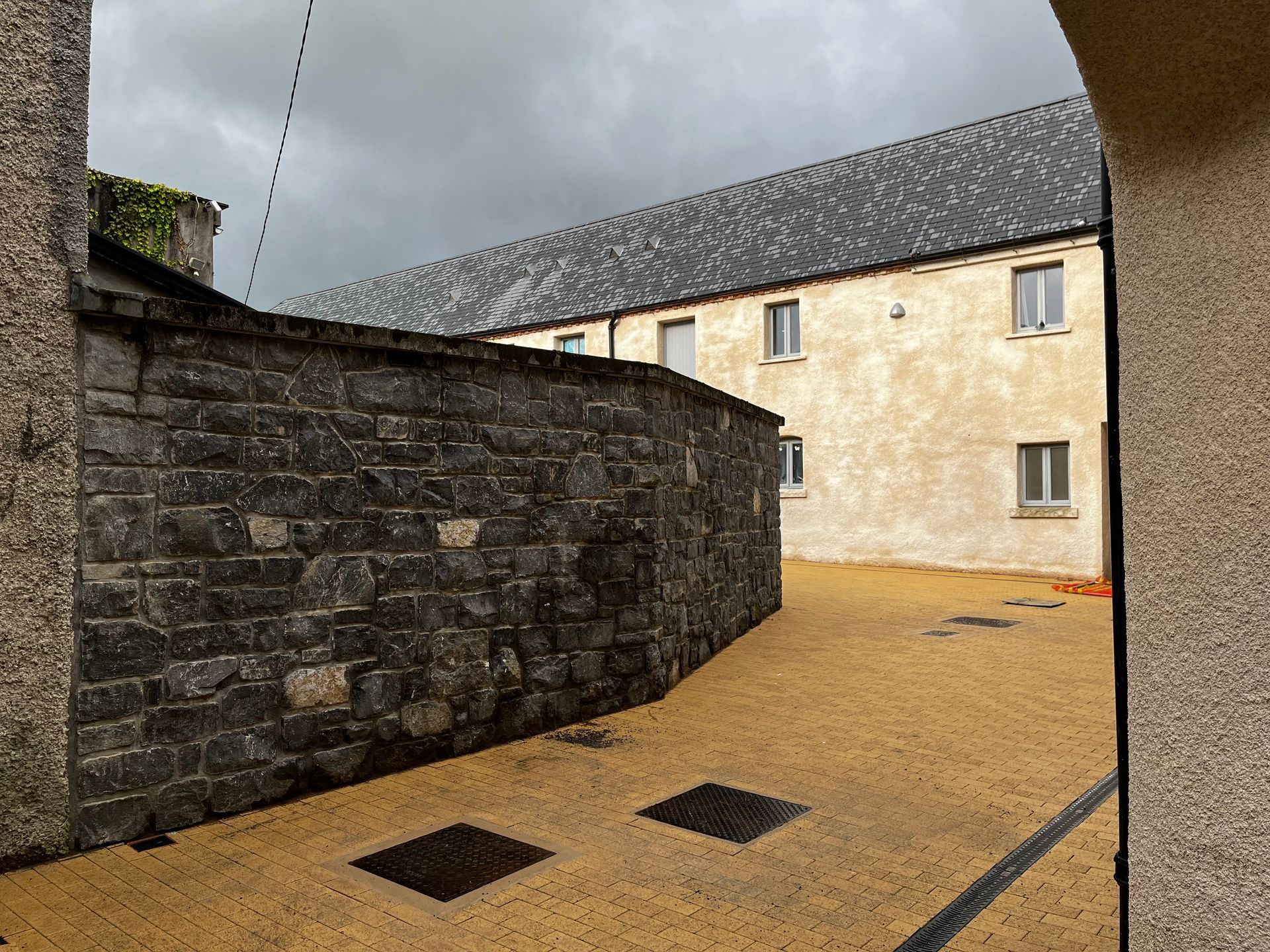 A building with a gray roof and a stone wall