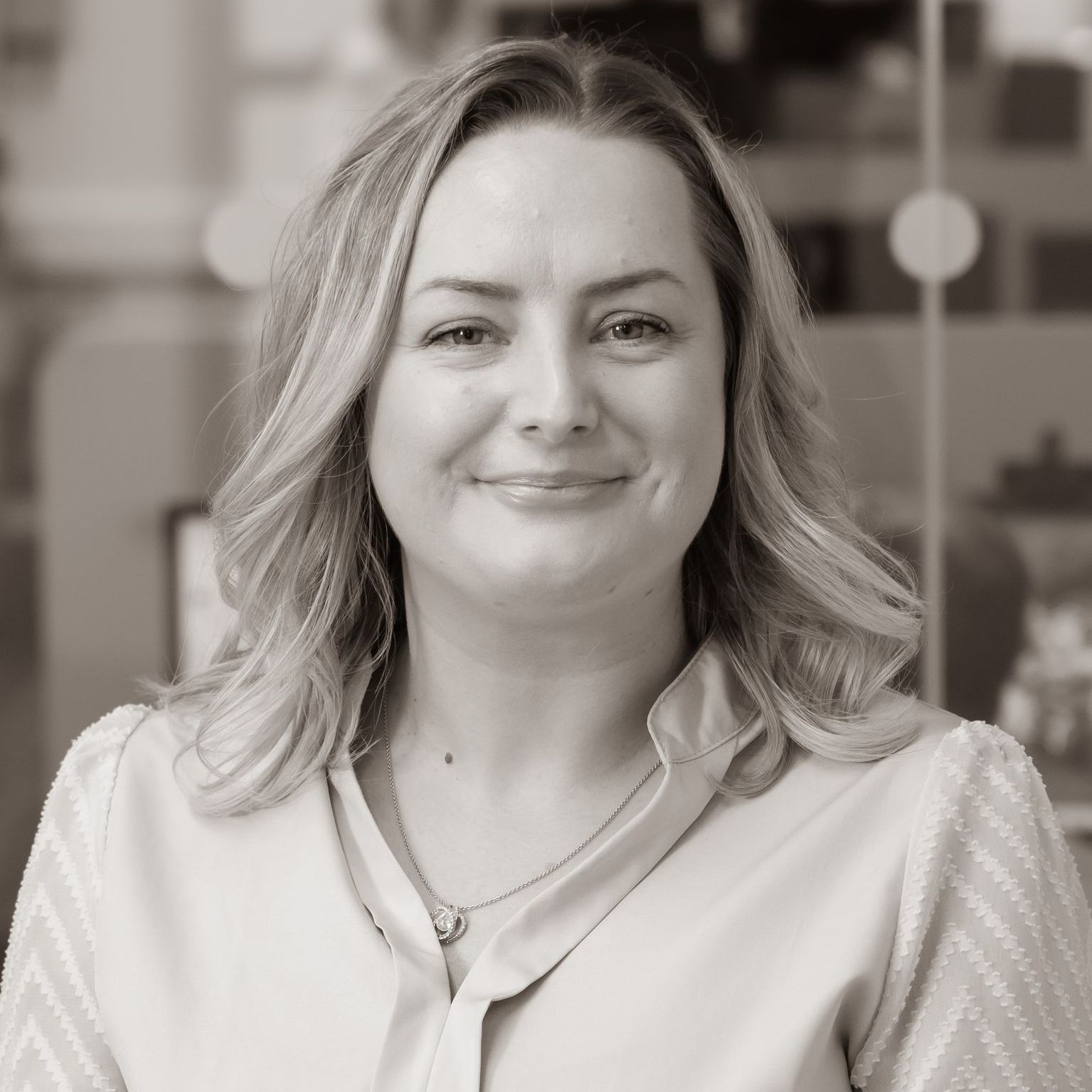 A woman is smiling in a black and white photo.