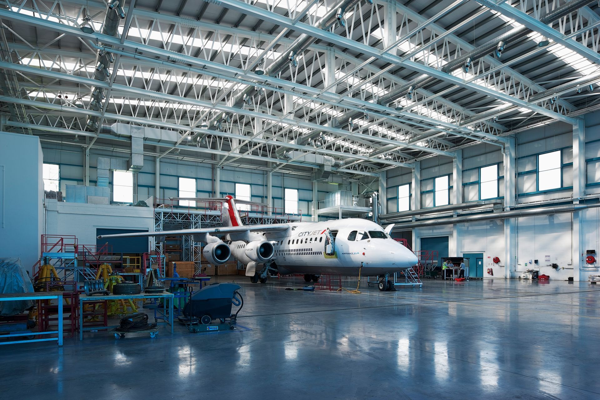 An airplane is parked inside of a large hangar.
