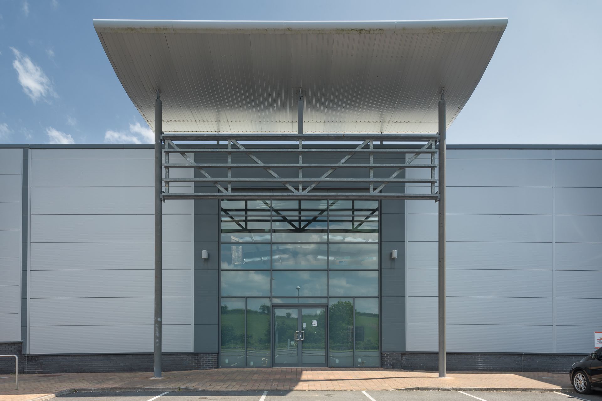 The front of a large building with a car parked in front of it.