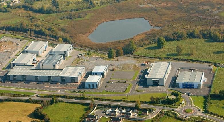 An aerial view of a industrial area with a pond in the middle