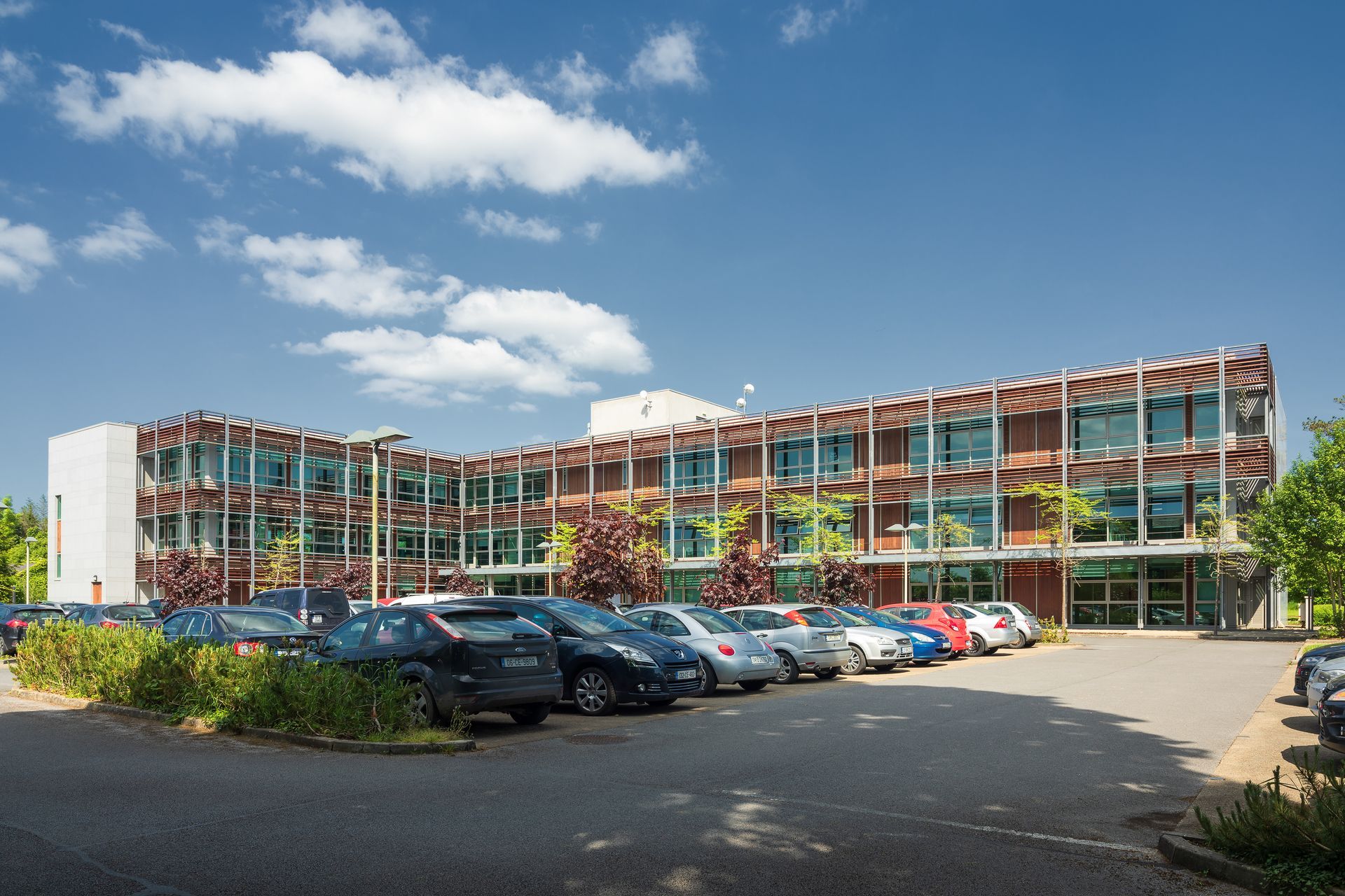 A large building with a lot of cars parked in front of it.