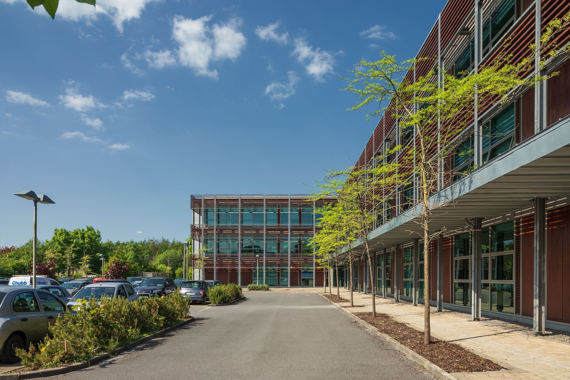 A parking lot with cars parked in front of a large building.