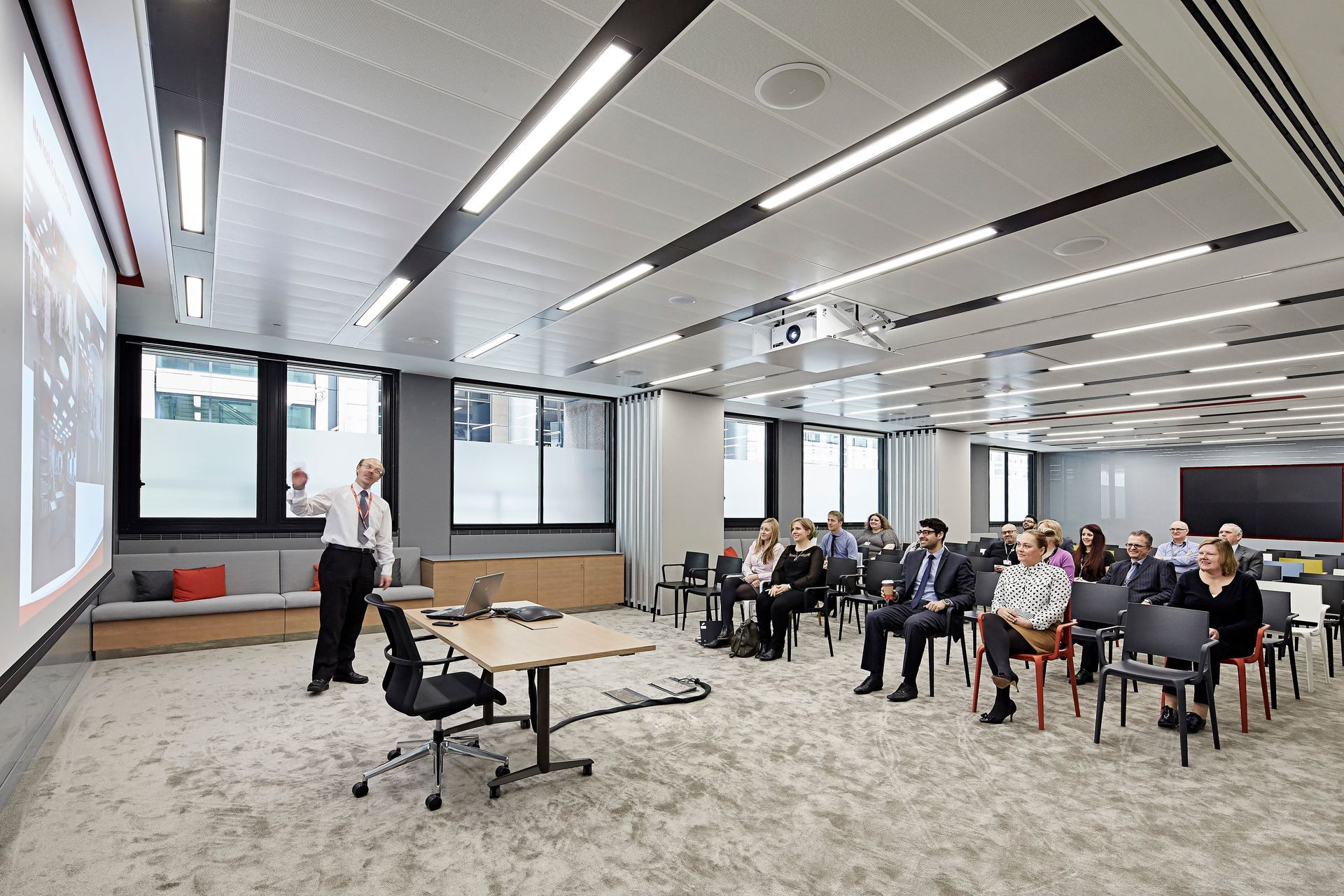 A man is giving a presentation to a group of people in a large room.