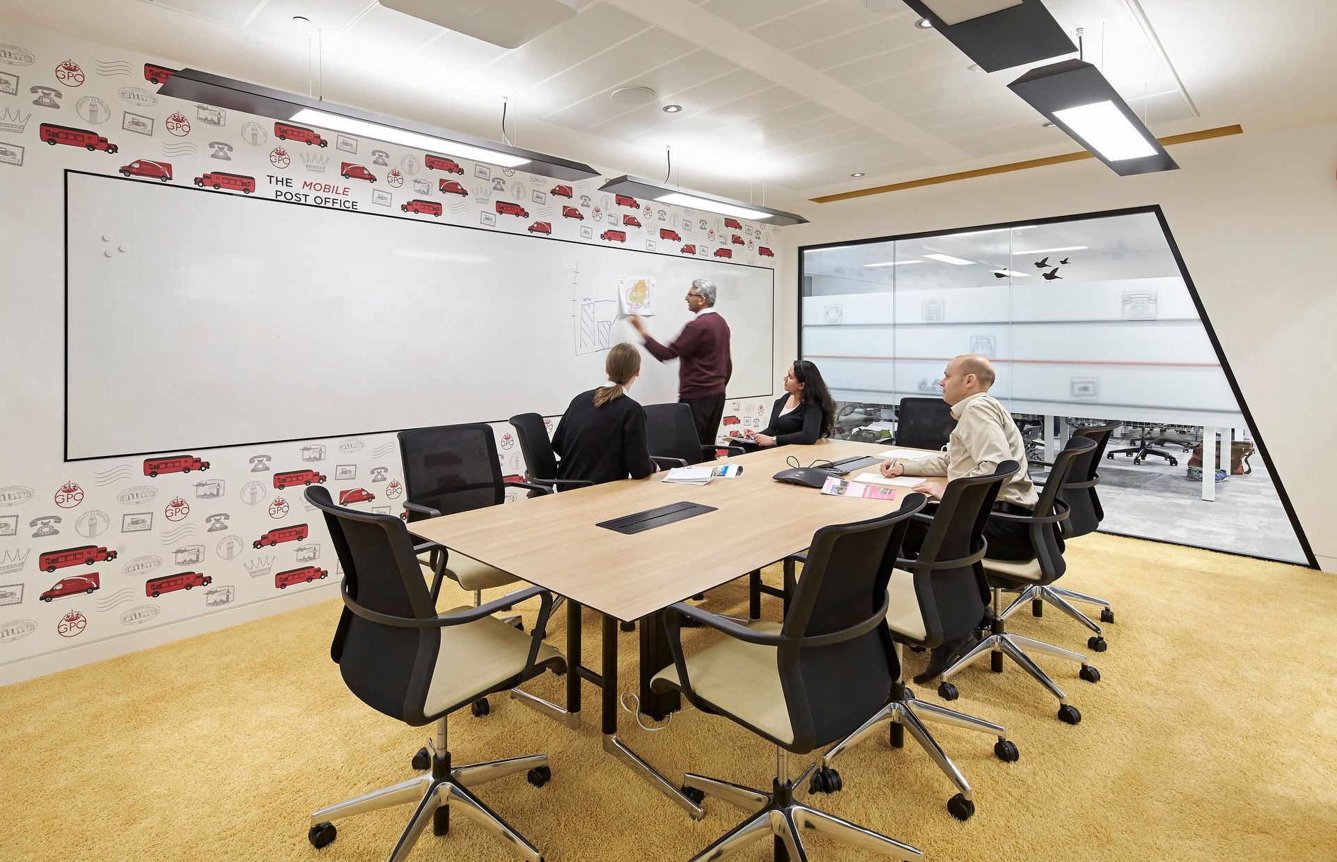 A group of people are sitting around a conference table in a conference room.