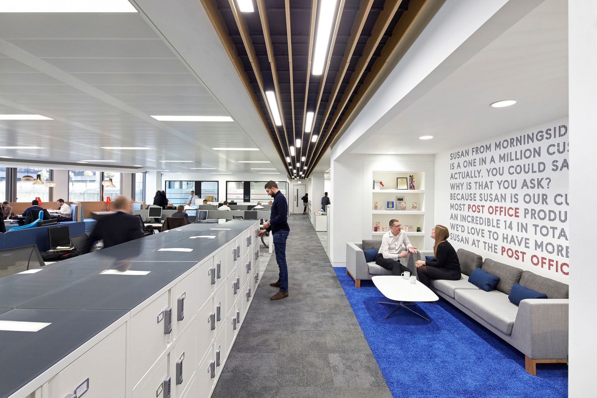 A group of people are sitting on a couch in an office.