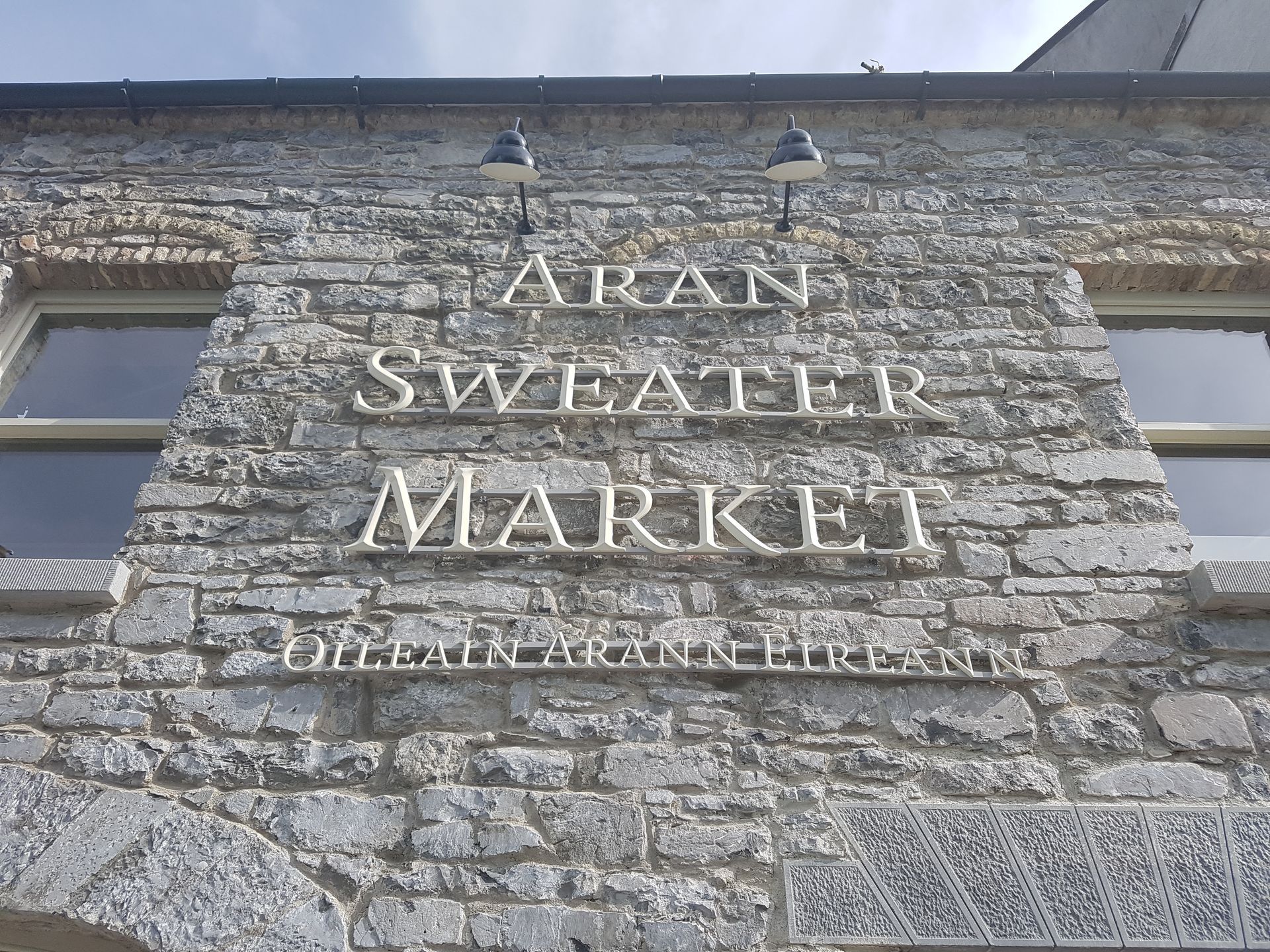 A brick building with a sign that says aran sweater market