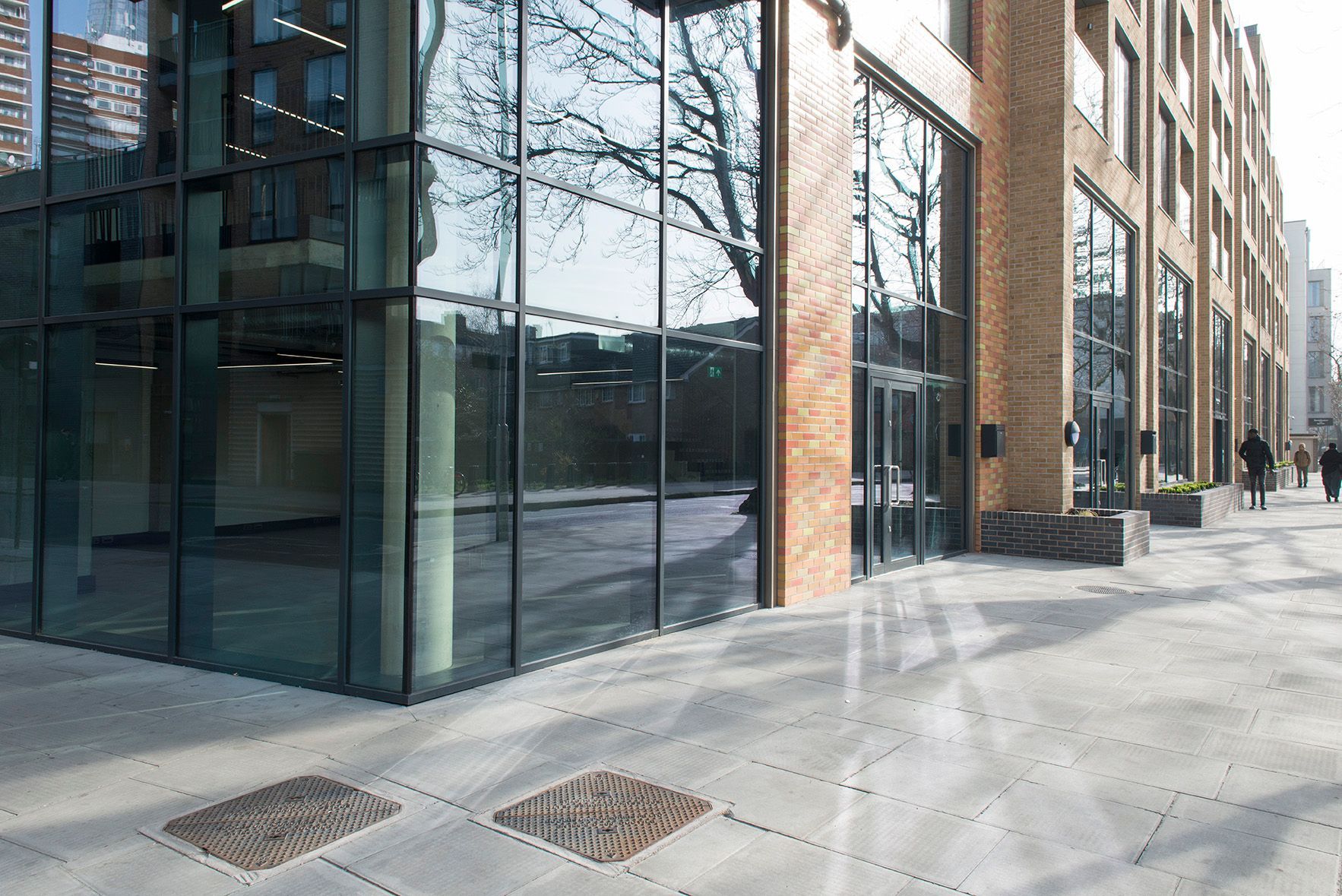 A large building with a lot of windows and people walking in front of it.