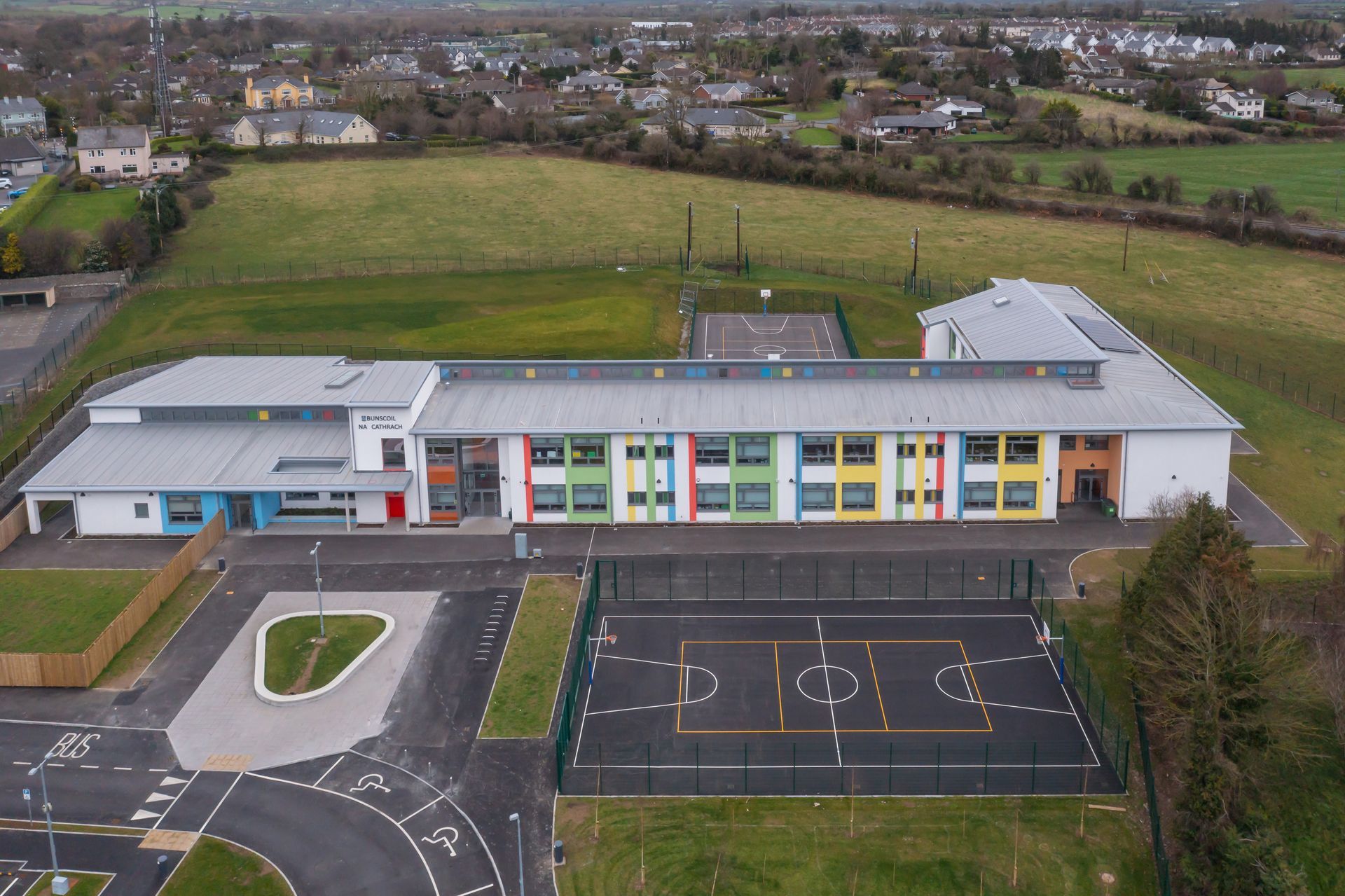 An aerial view of a school with a playground in front of it