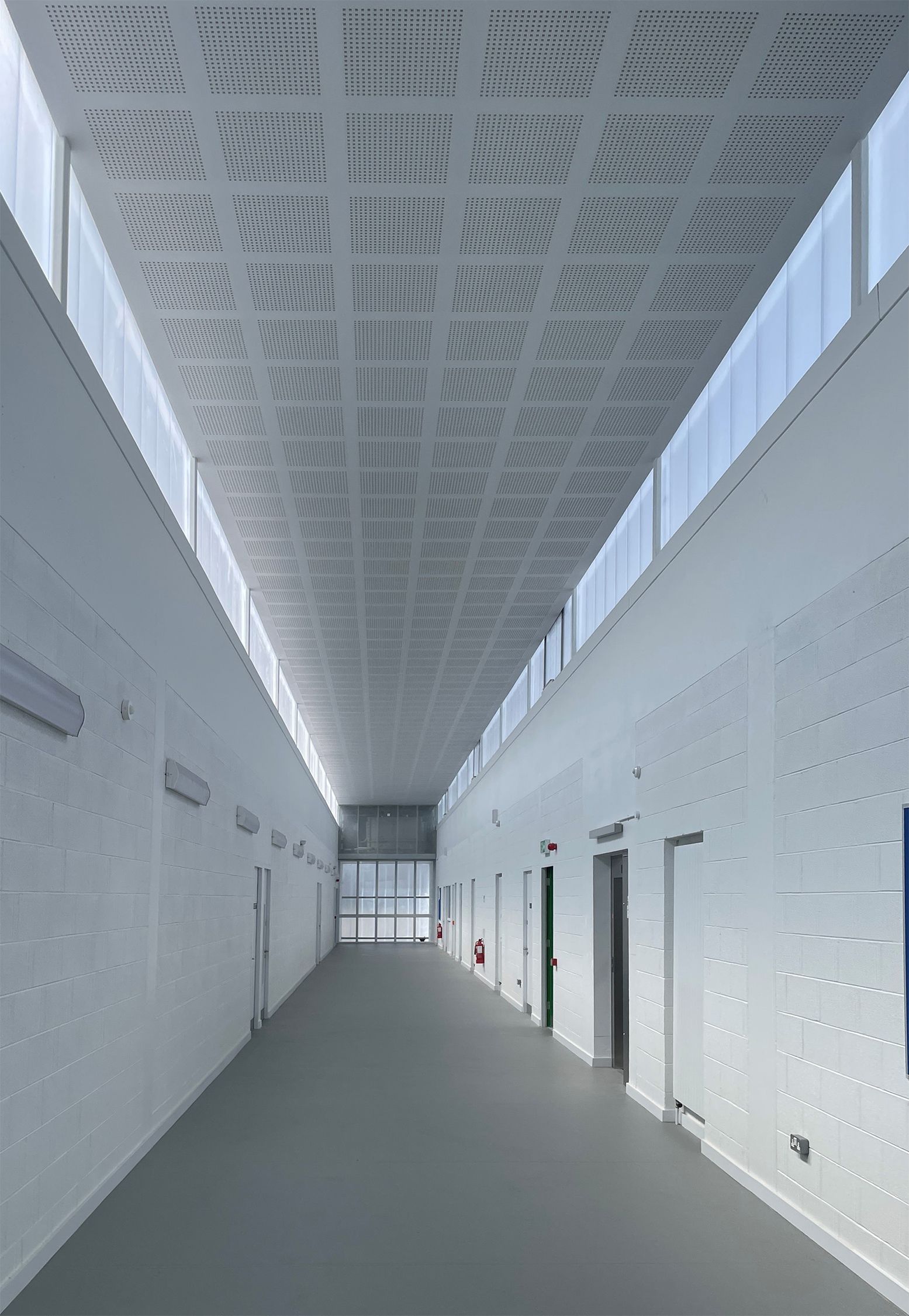 A long hallway with a ceiling that has holes in it