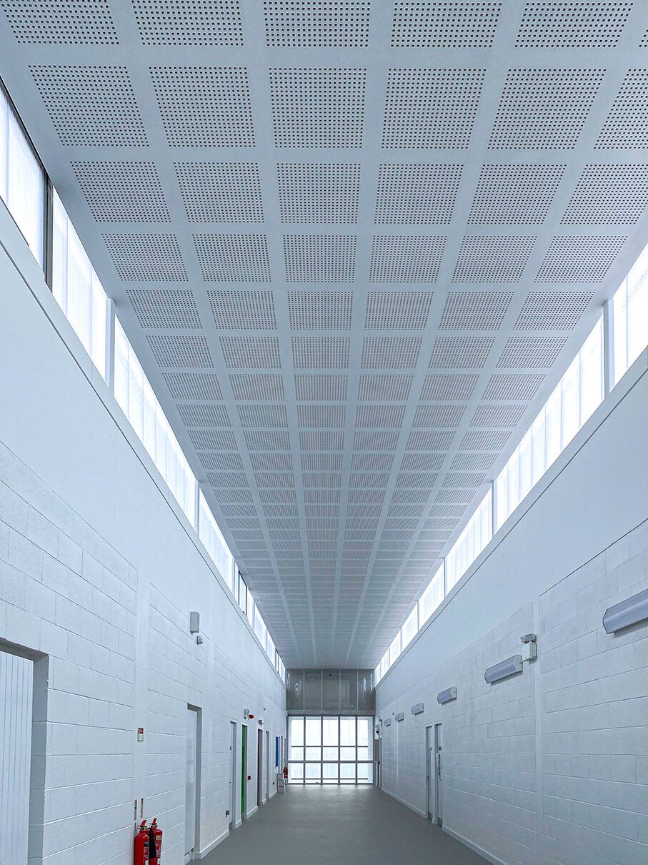 A long hallway with a ceiling that has holes in it