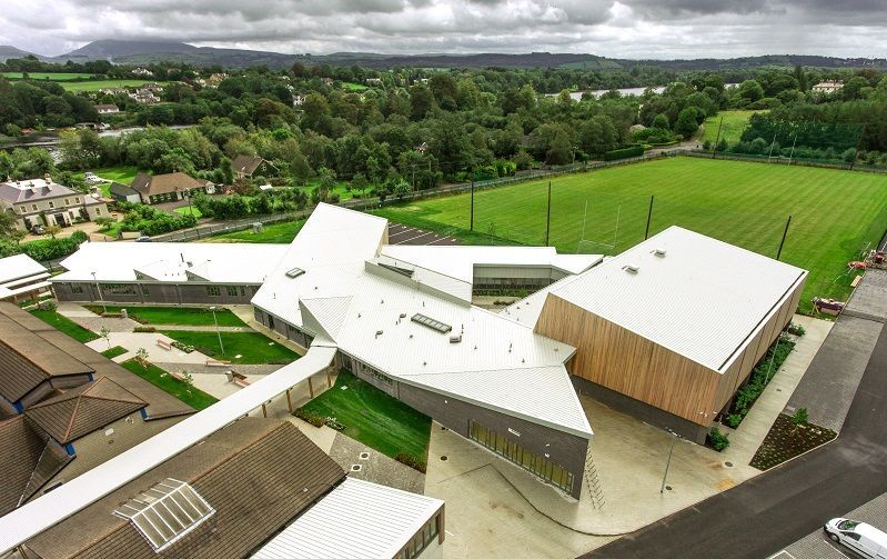 An aerial view of a large building with a white roof