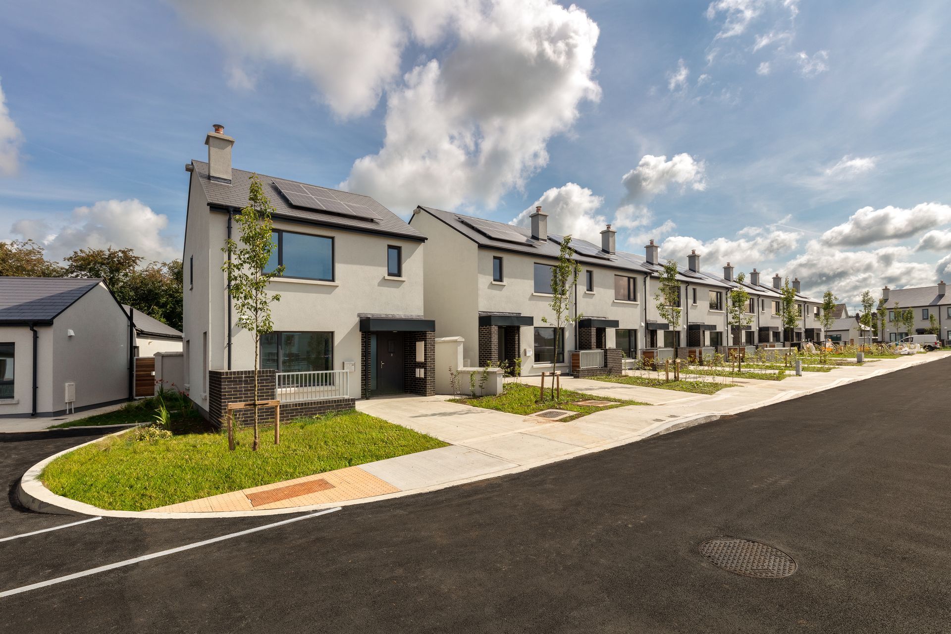 A row of houses are lined up on the side of a road.