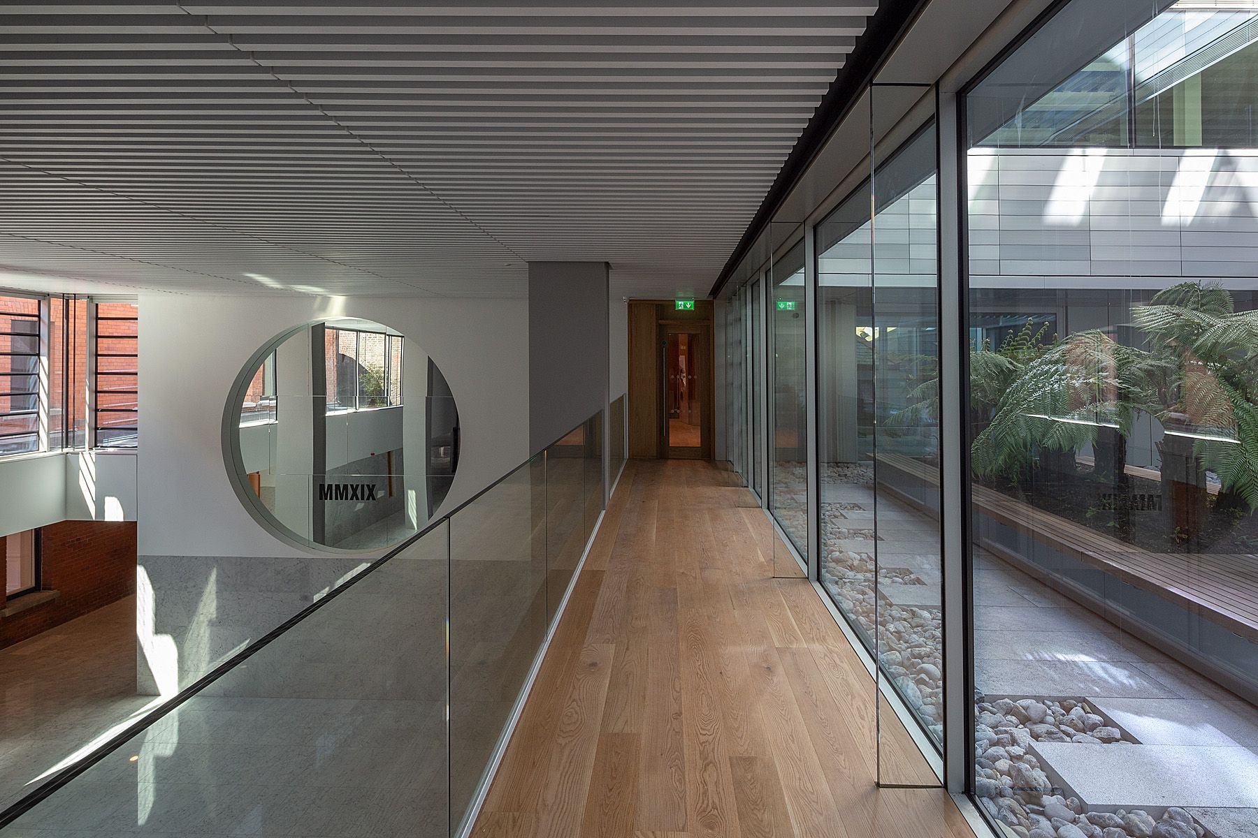 A long hallway with a glass railing and lots of windows