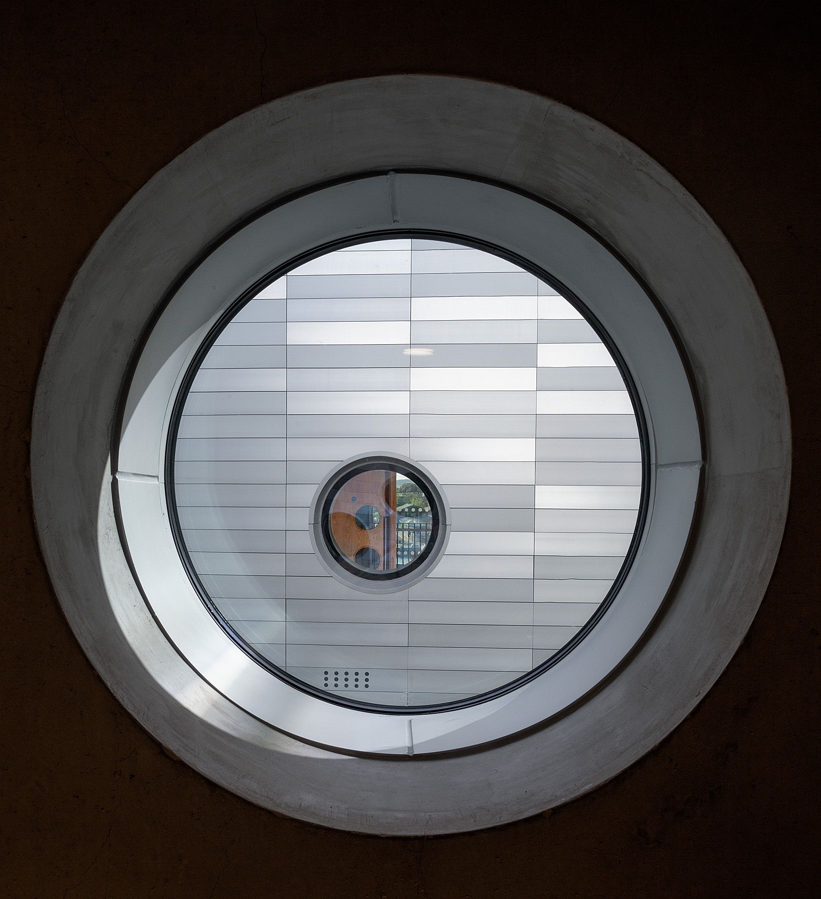 A round window with a reflection of a building in it