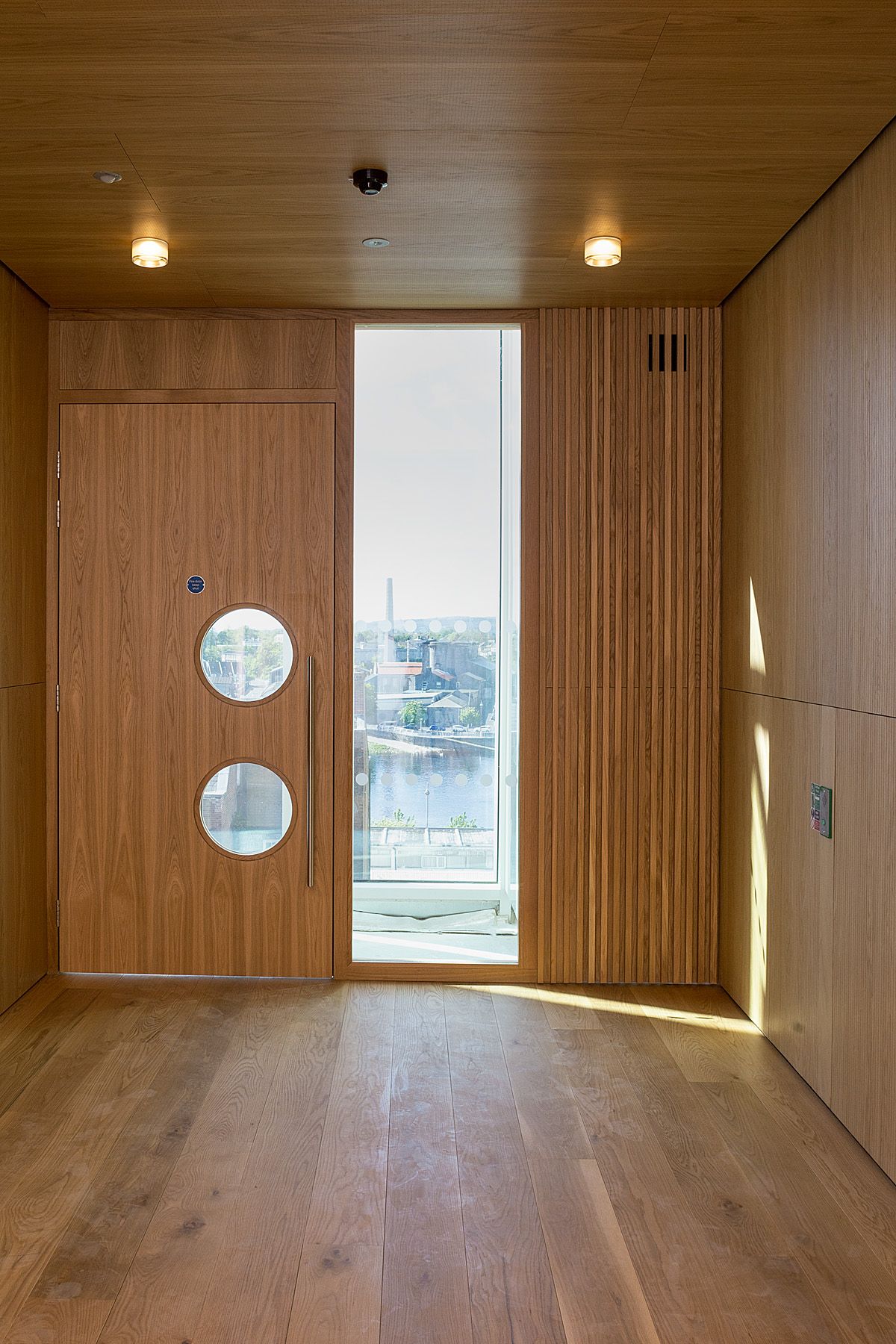 A room with a wooden door and a large window.
