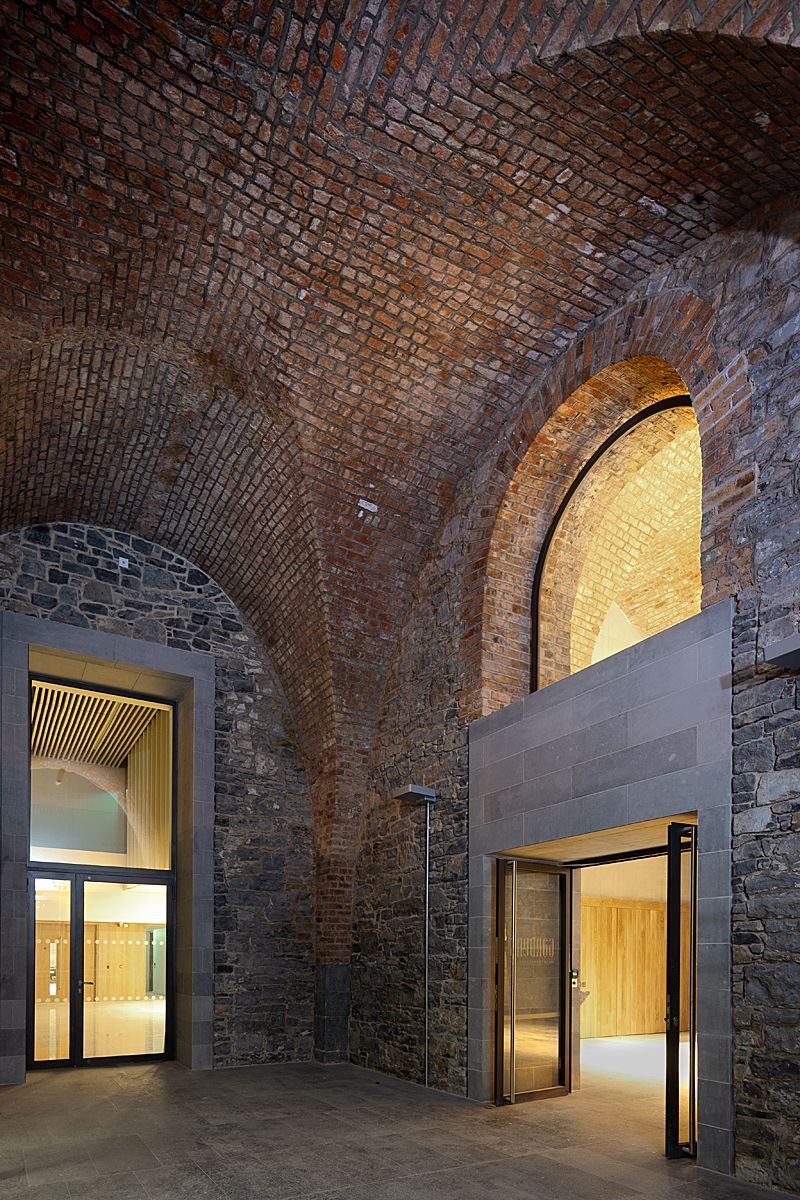 A large room with a brick ceiling and arched windows.