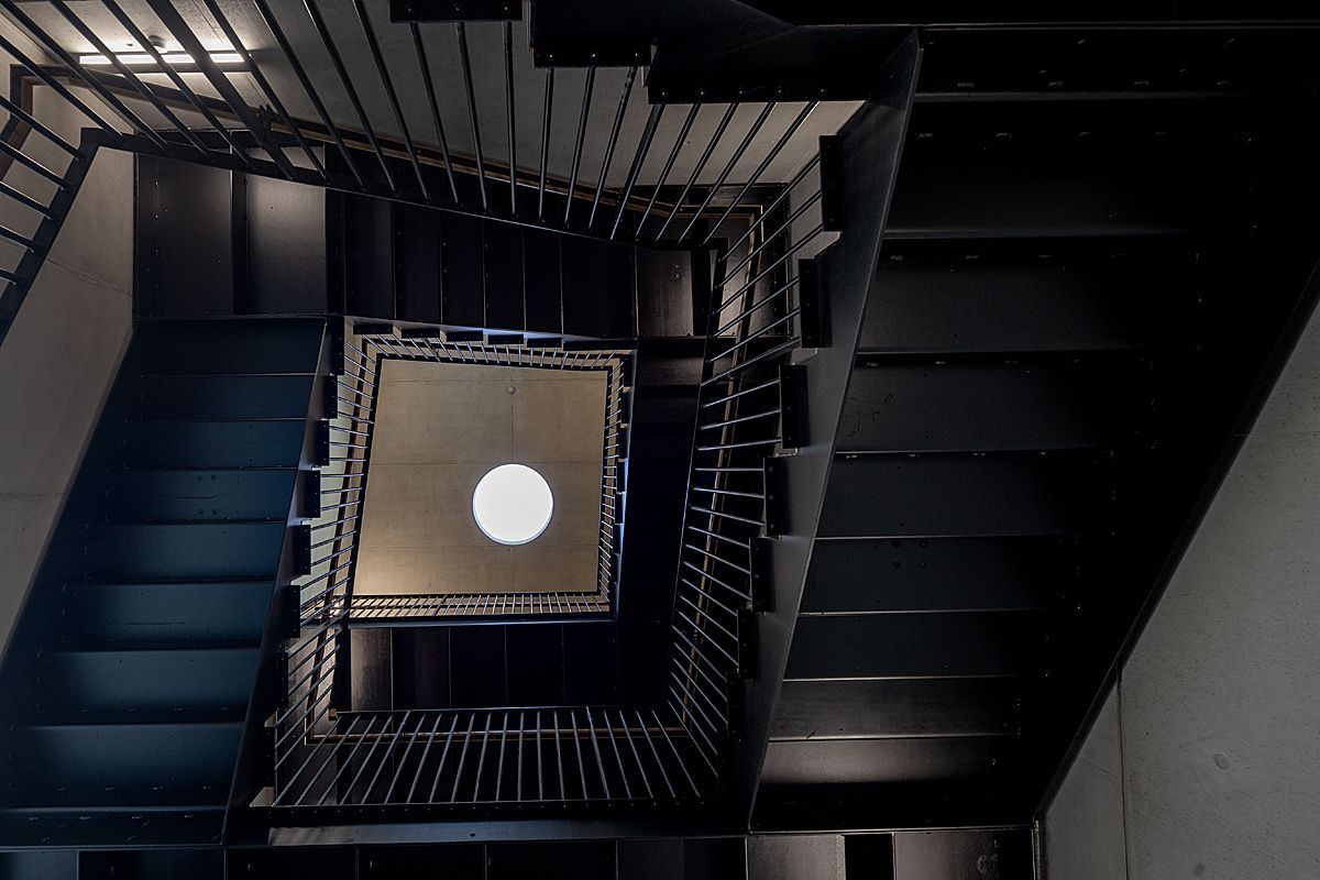 Looking up at a staircase with a light hanging from the ceiling