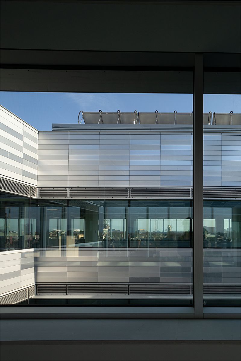 A view of a building through a window with a blue sky in the background.