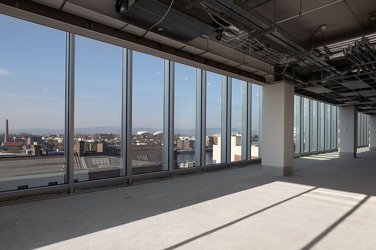 An empty room with a lot of windows and a view of a city