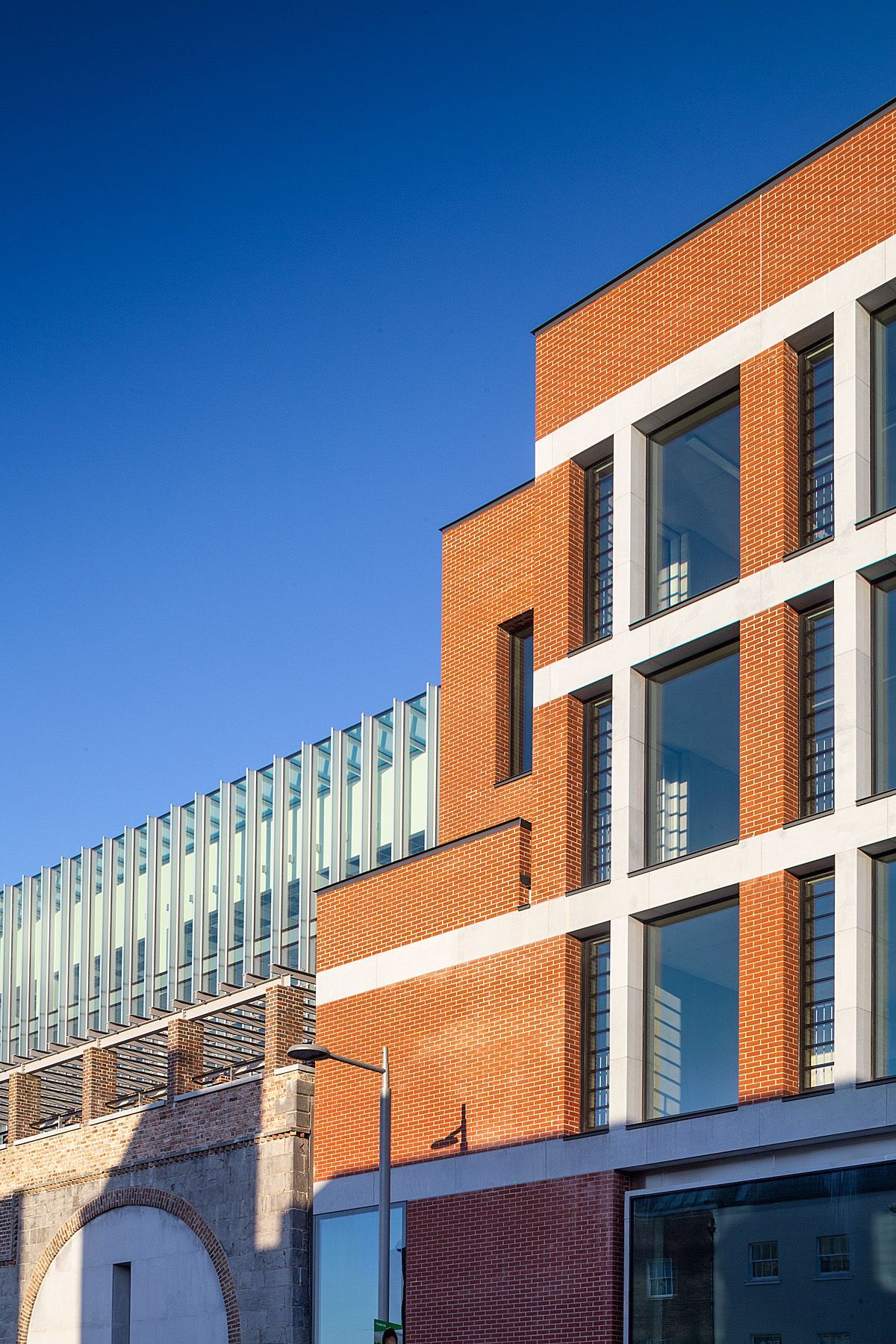 A brick building with a lot of windows and a blue sky in the background