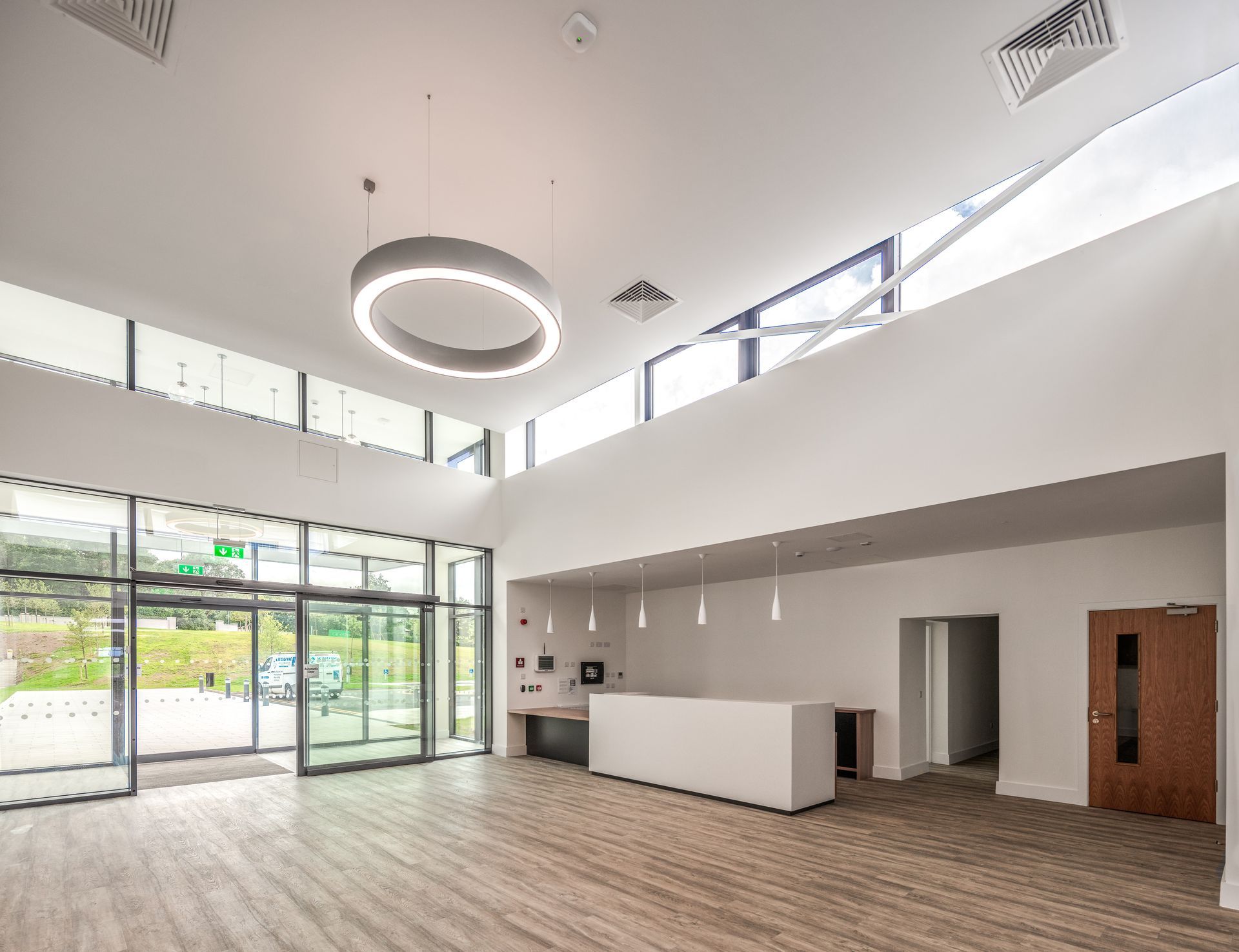 A large empty room with wooden floors and a ceiling light.