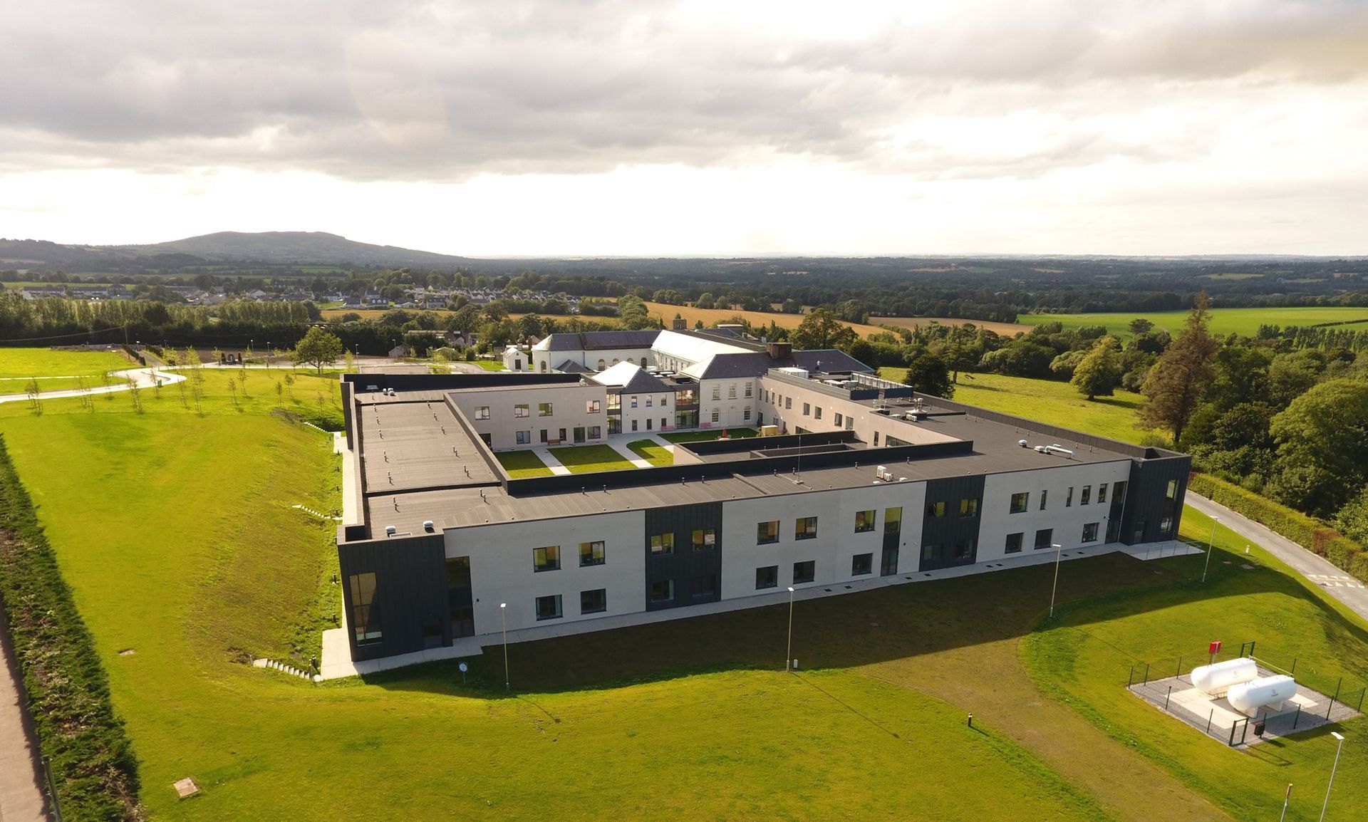 An aerial view of a large building in the middle of a field.