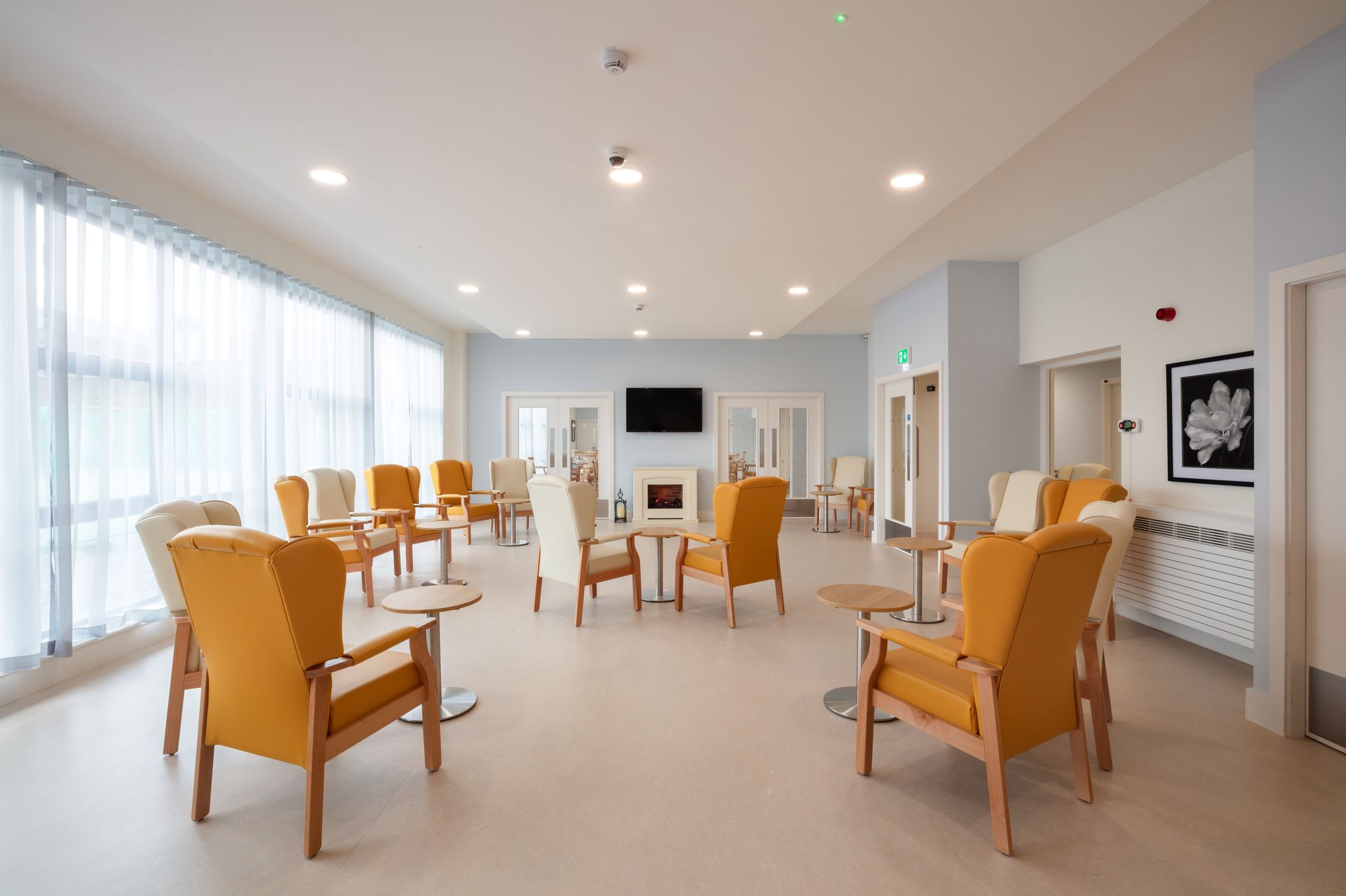 There are many chairs and tables in the room.