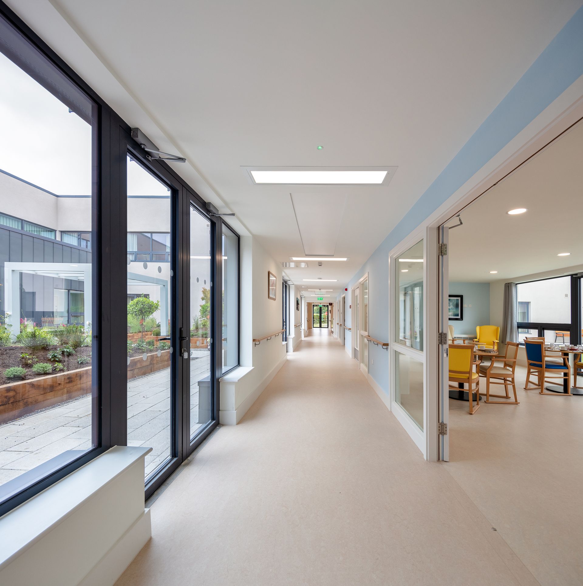 A long hallway with a lot of windows and chairs