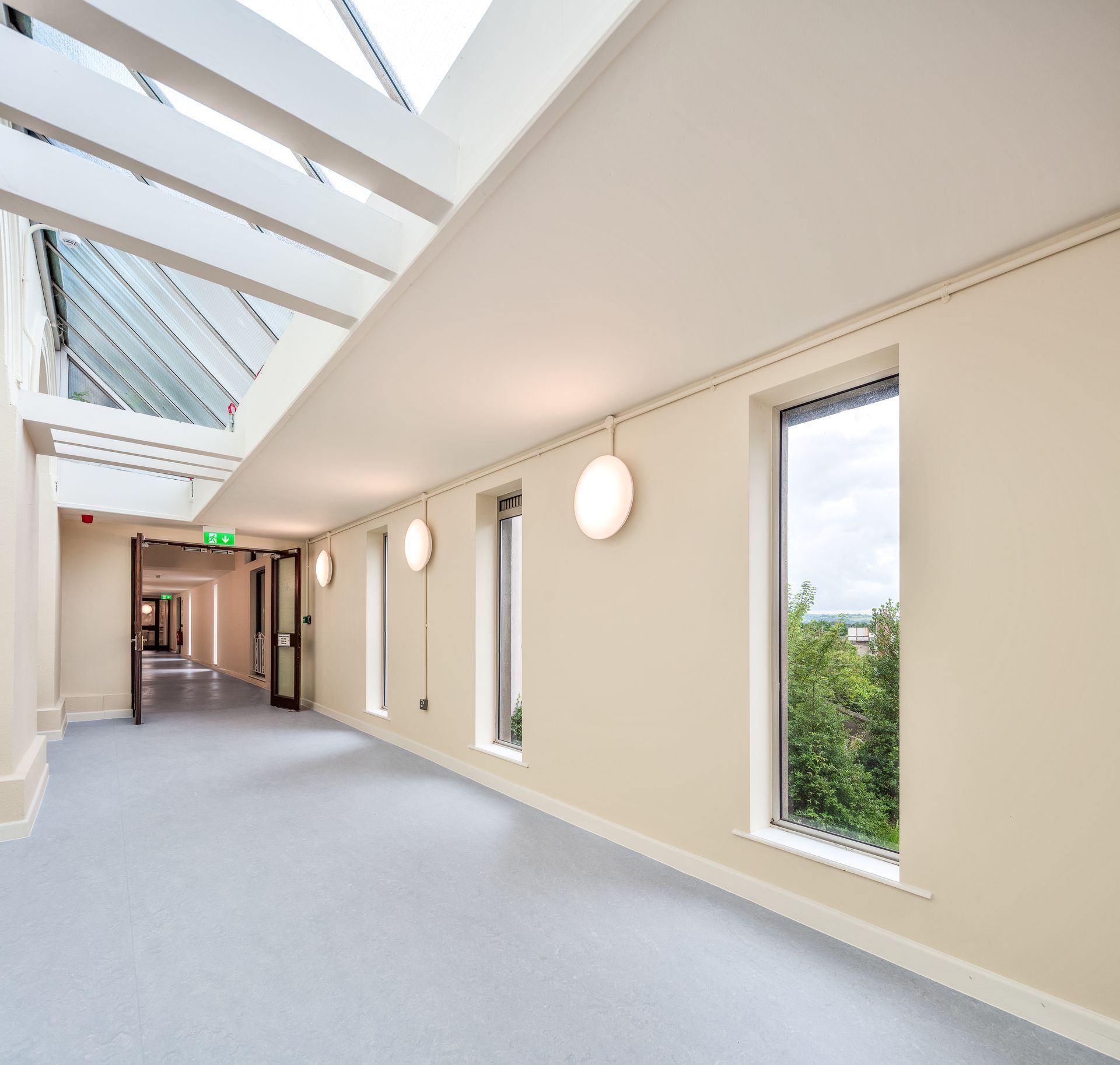 A long hallway with lots of windows and a skylight