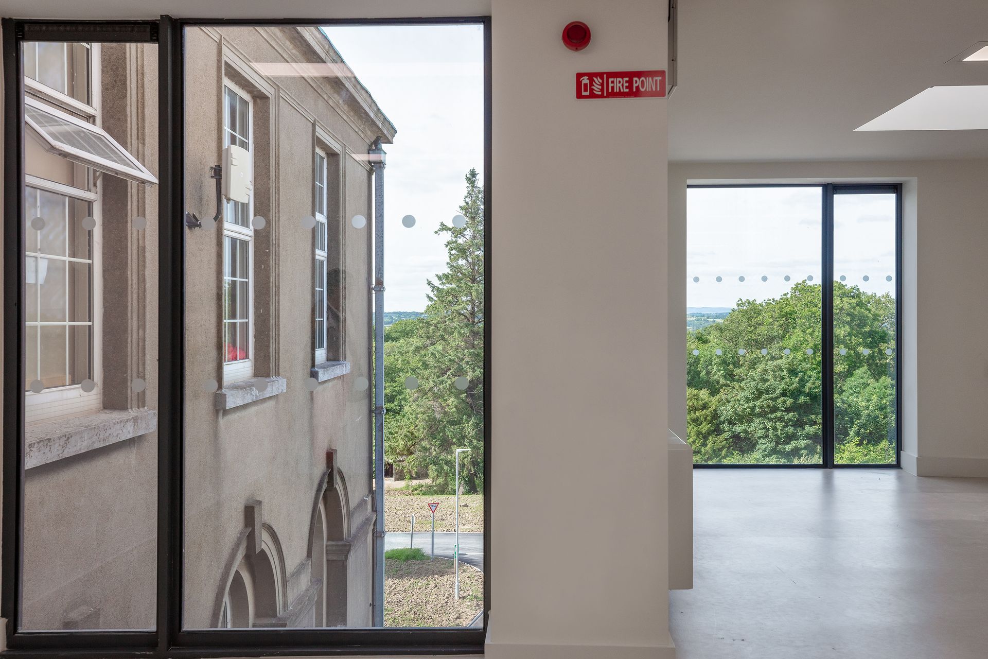 A building with a lot of windows and a fire extinguisher on the wall.
