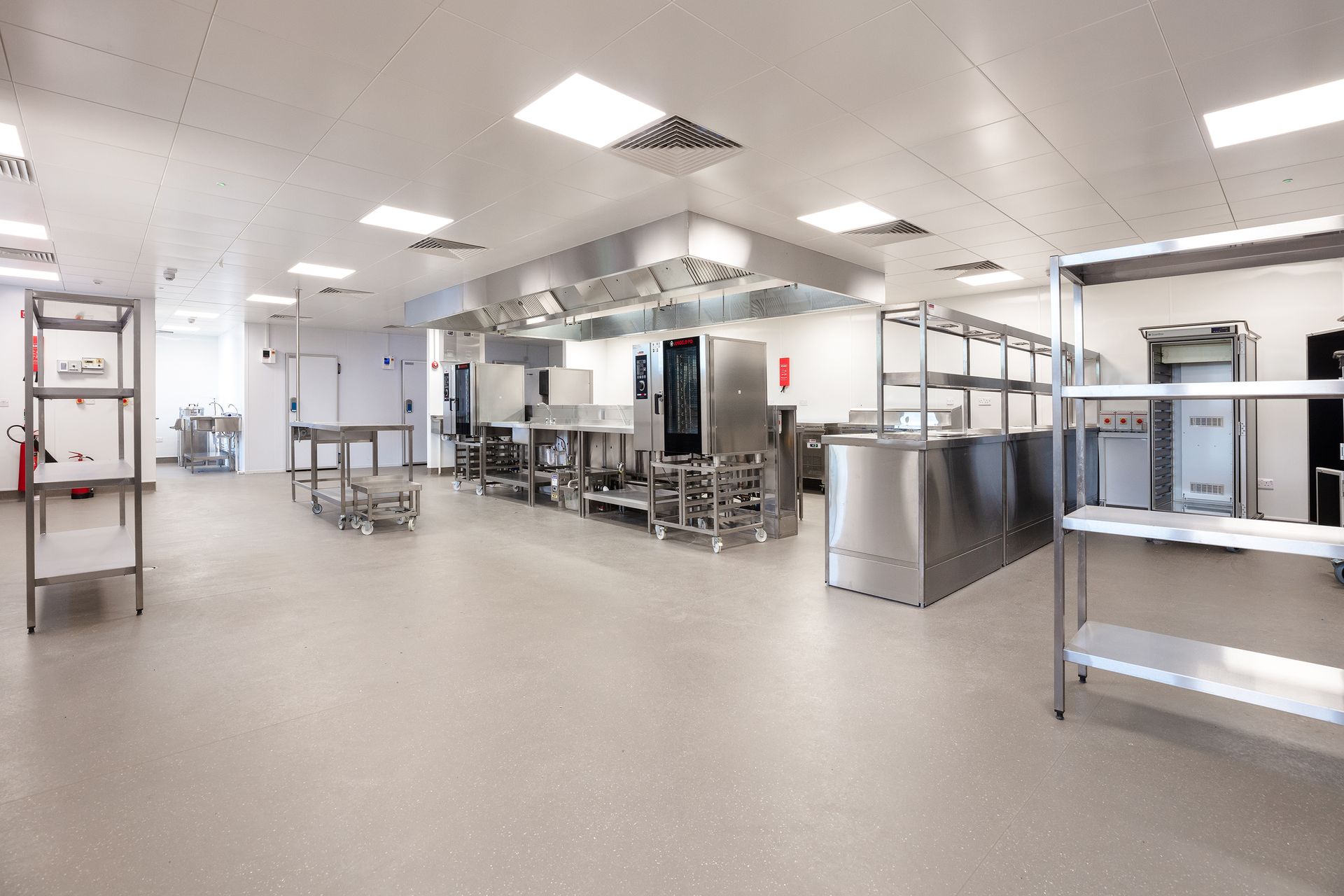 A large kitchen with stainless steel appliances and shelves.