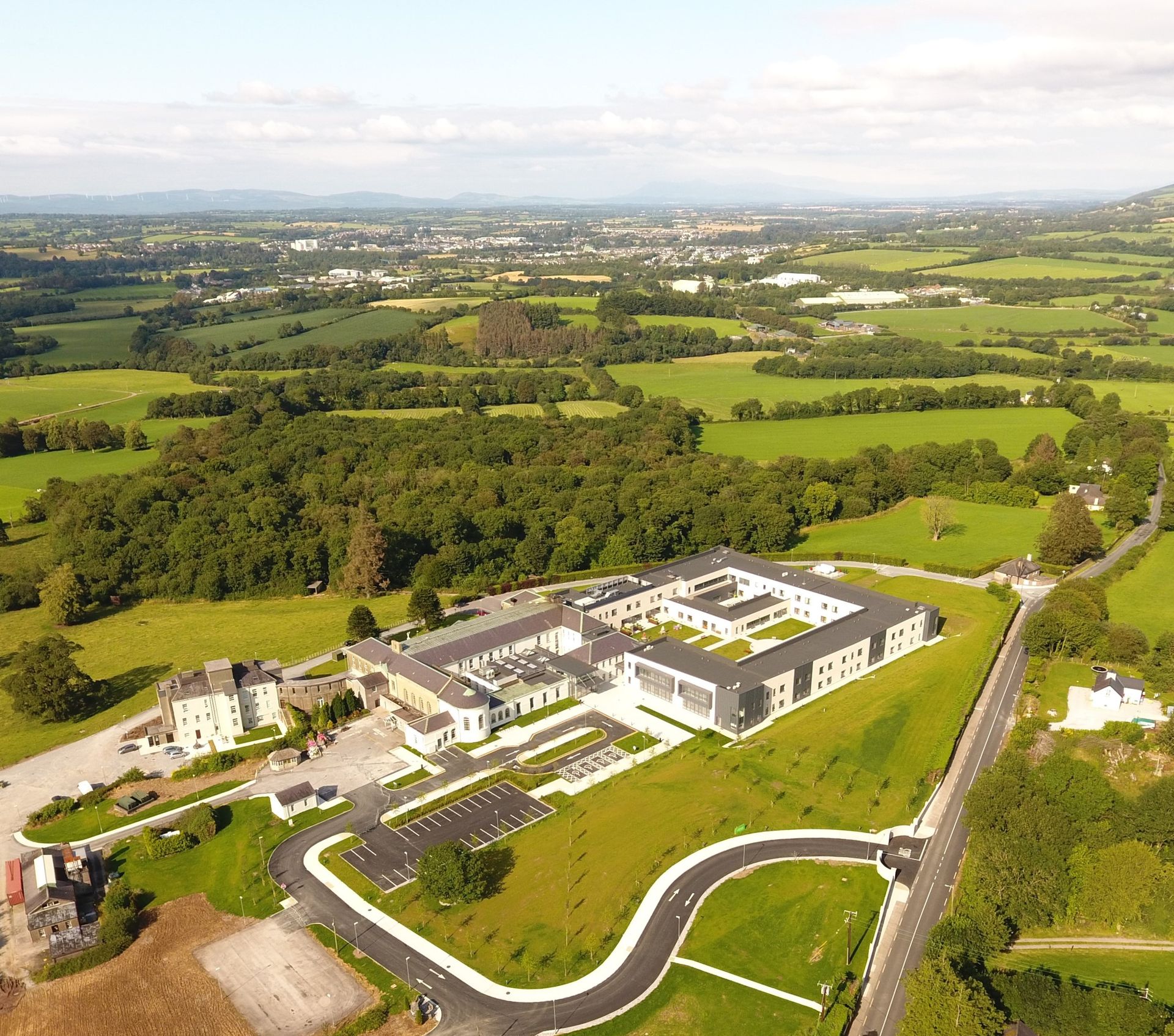 An aerial view of a large building in the middle of a field
