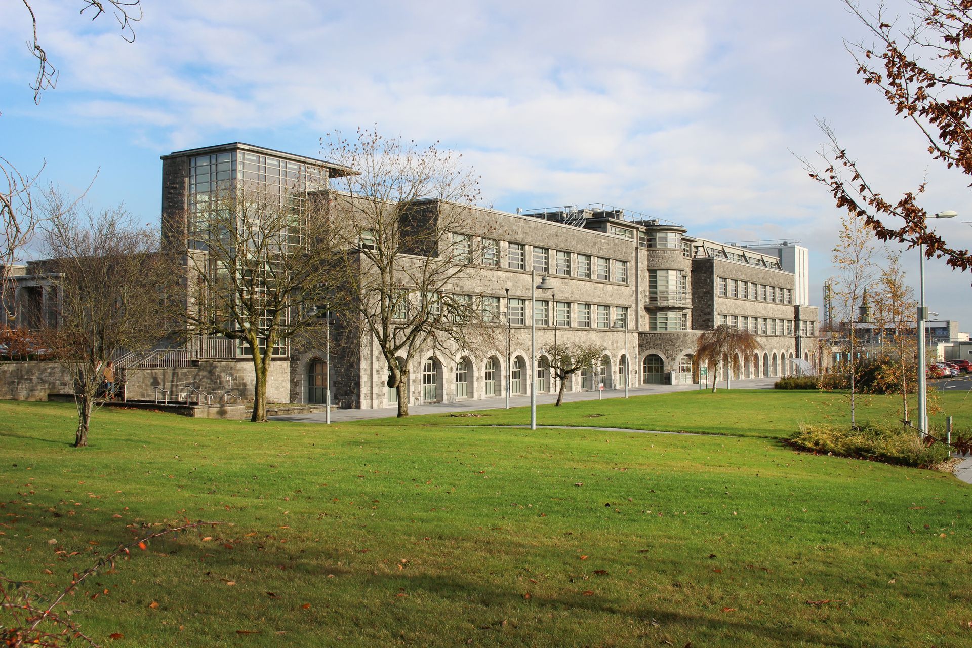 A large building is surrounded by grass and trees
