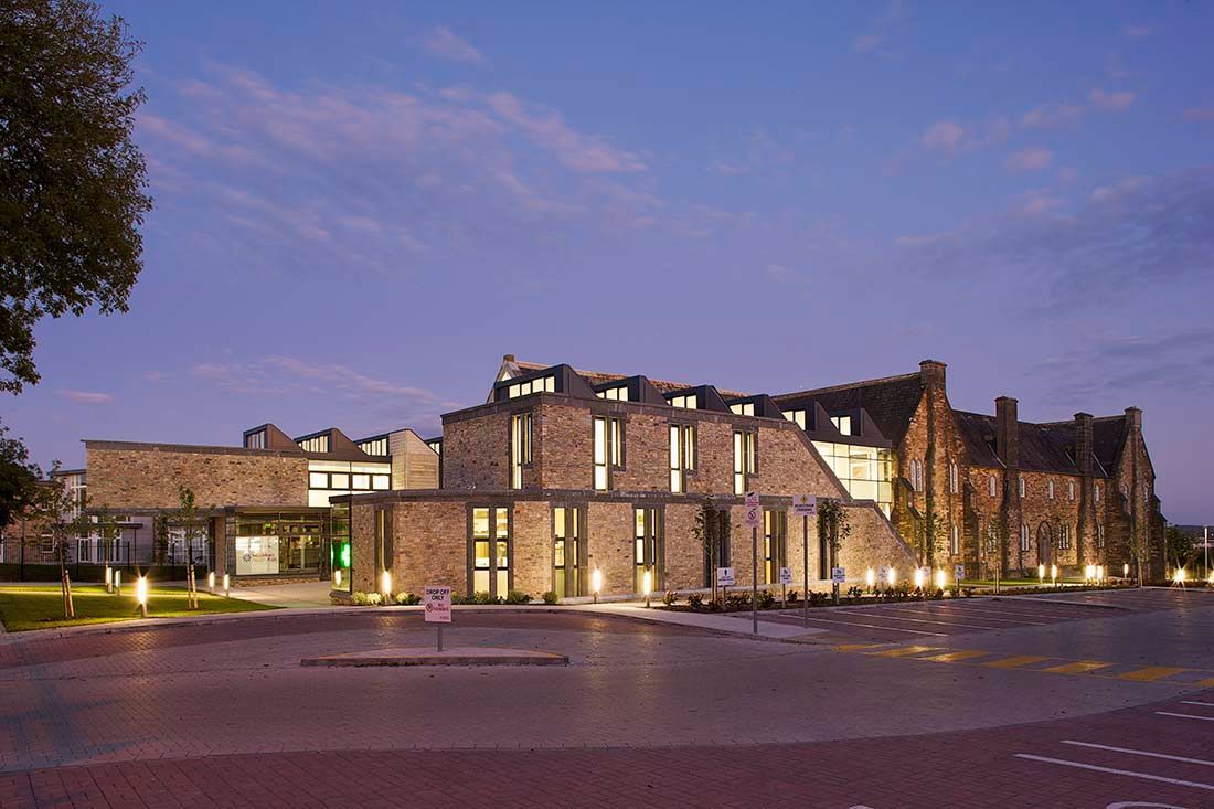 A large building with a lot of windows is lit up at night.