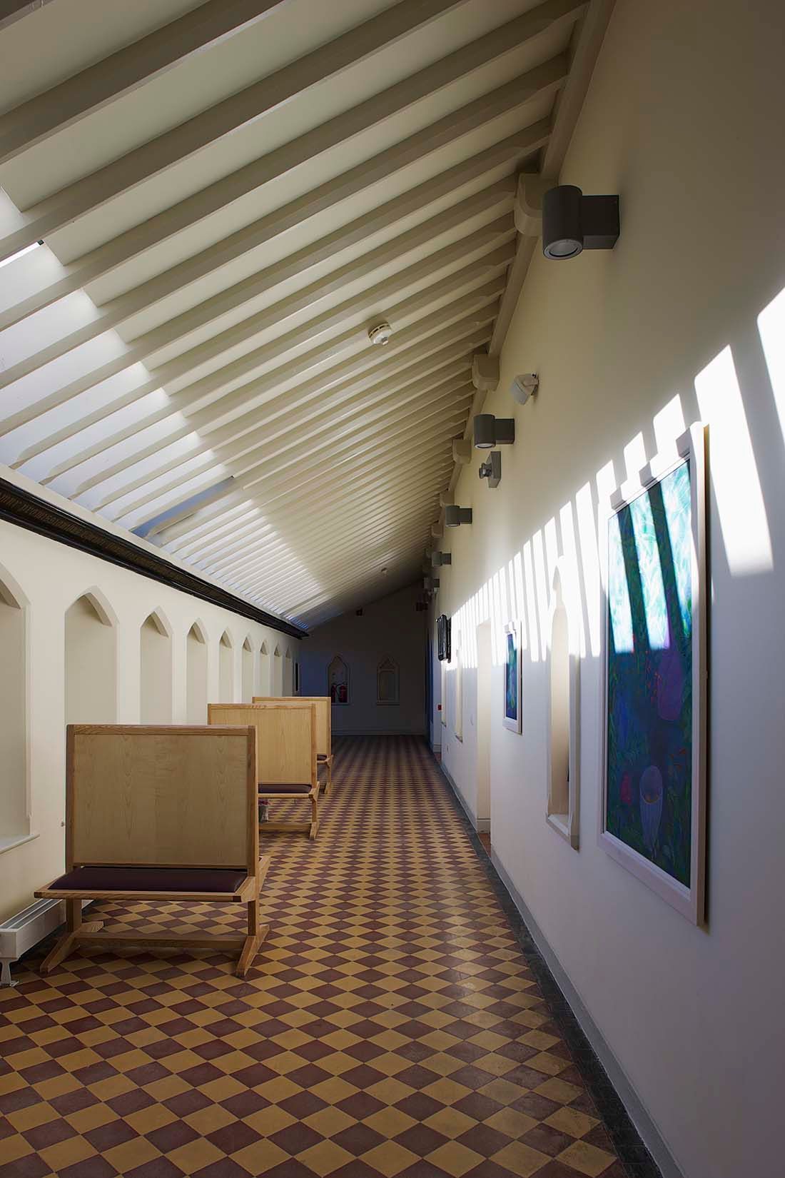 A long hallway with chairs and a checkered floor